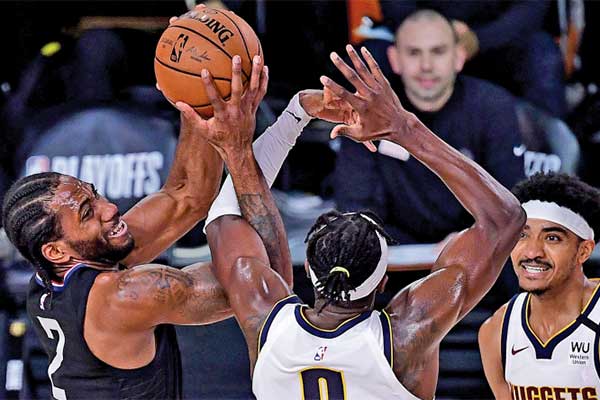 Pemain LA Clippers Kawhi Leonard (kiri) harus beradu kuat untuk menguasai bola dengan pemain Denver Nuggets Jerami Grant