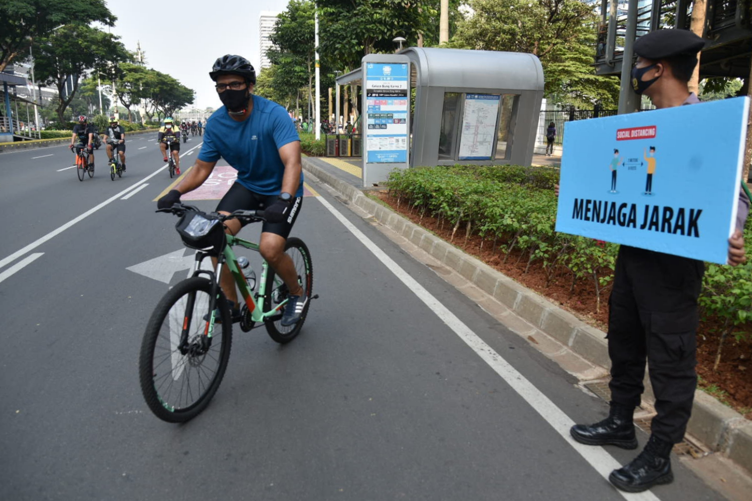 Petugas melakukan imbauan menjaga jarak melalui poster di Jalan Sudirman, Jakarta, Minggu (6/9).