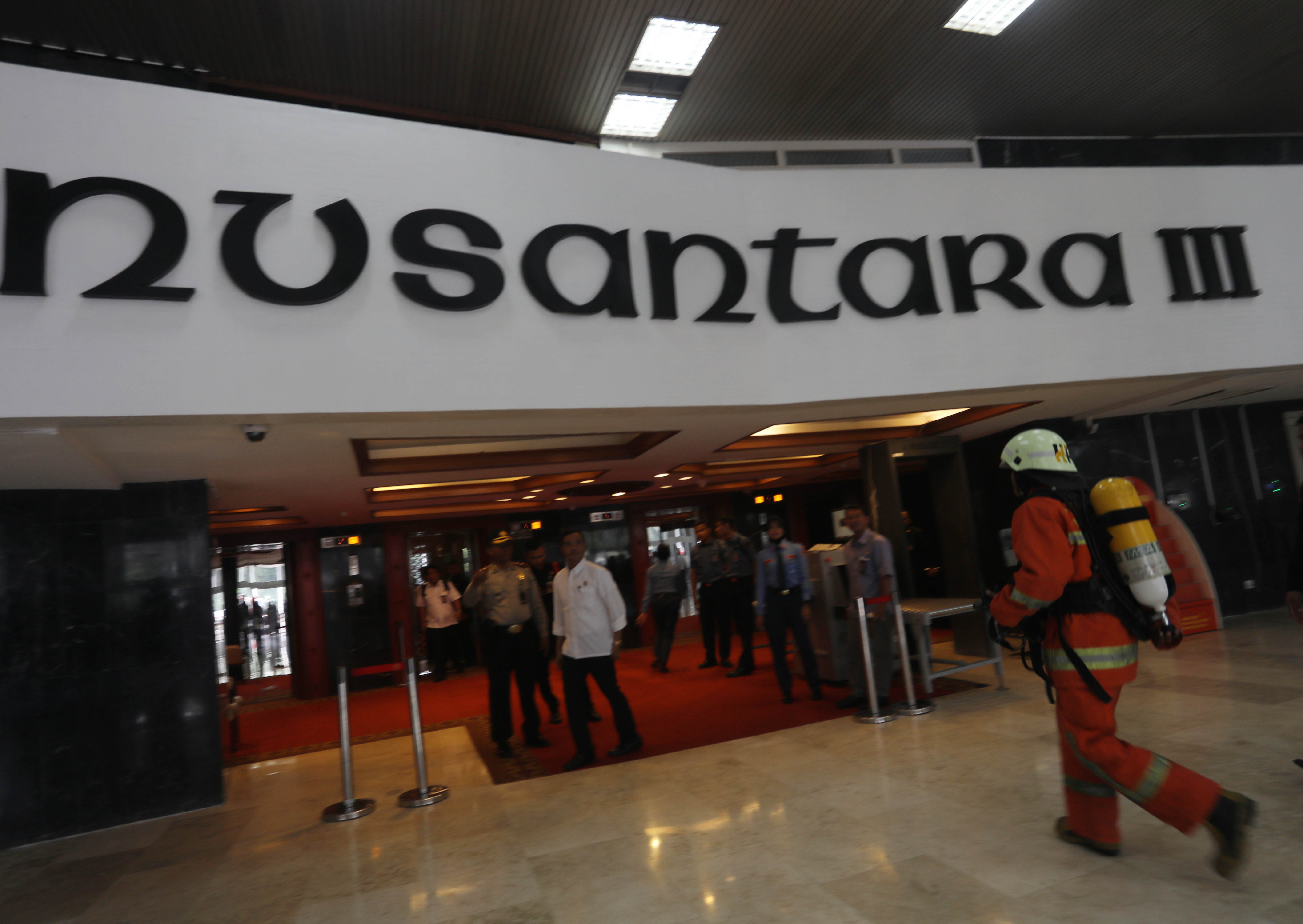 Petugas bergegas memadamkan lift yang terbakar di Gedung Nusantara I