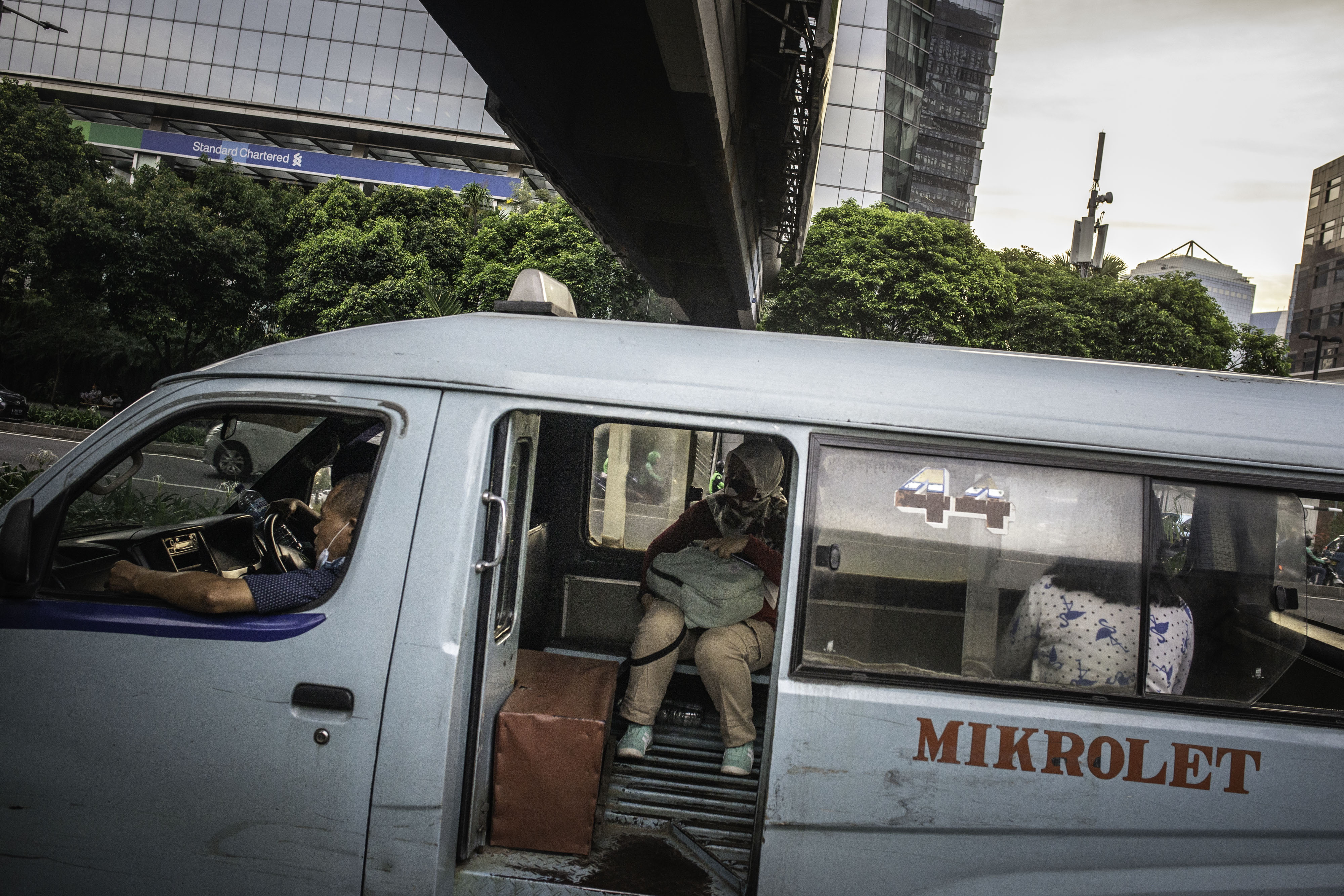 Penumpang duduk menumpang angkutan kota Mikrolet di kawasan Karet Kuningan, Jakarta, Jumat (25/9/2020).