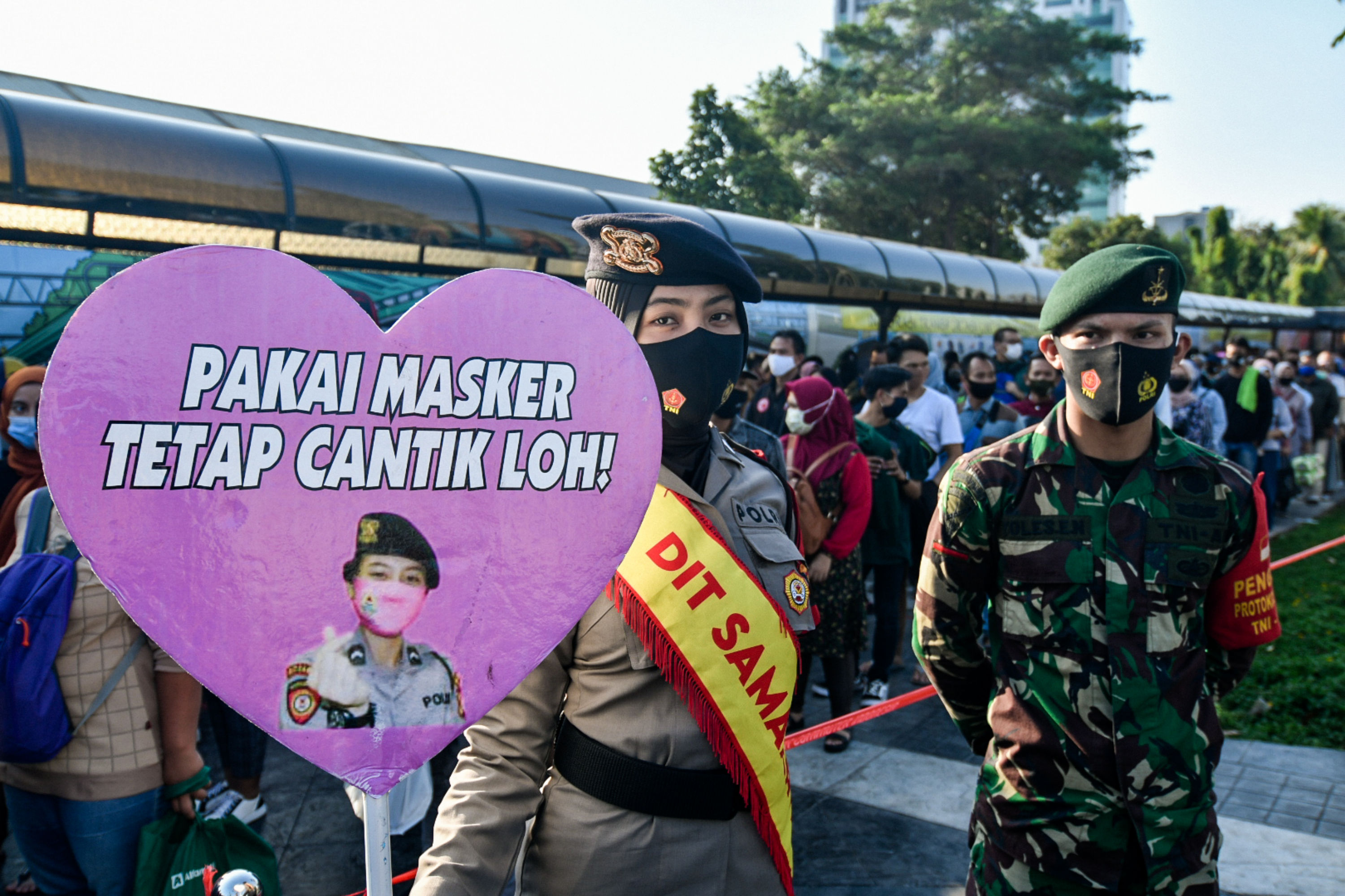 Anggota Polisi menyosialisasikan penggunaan masker untuk calon penumpang KRL Commuterline di Stasiun Tanah Abang, Jakarta.