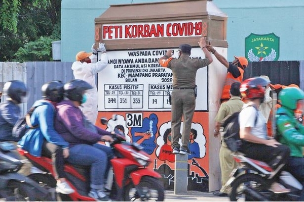 Petugasi Kelurahan Bangka, Mampang Prapatan, memasang replika peti jenazah korban covid-19 di perempatan Jalan Kemang 1, Jakarta Selatan