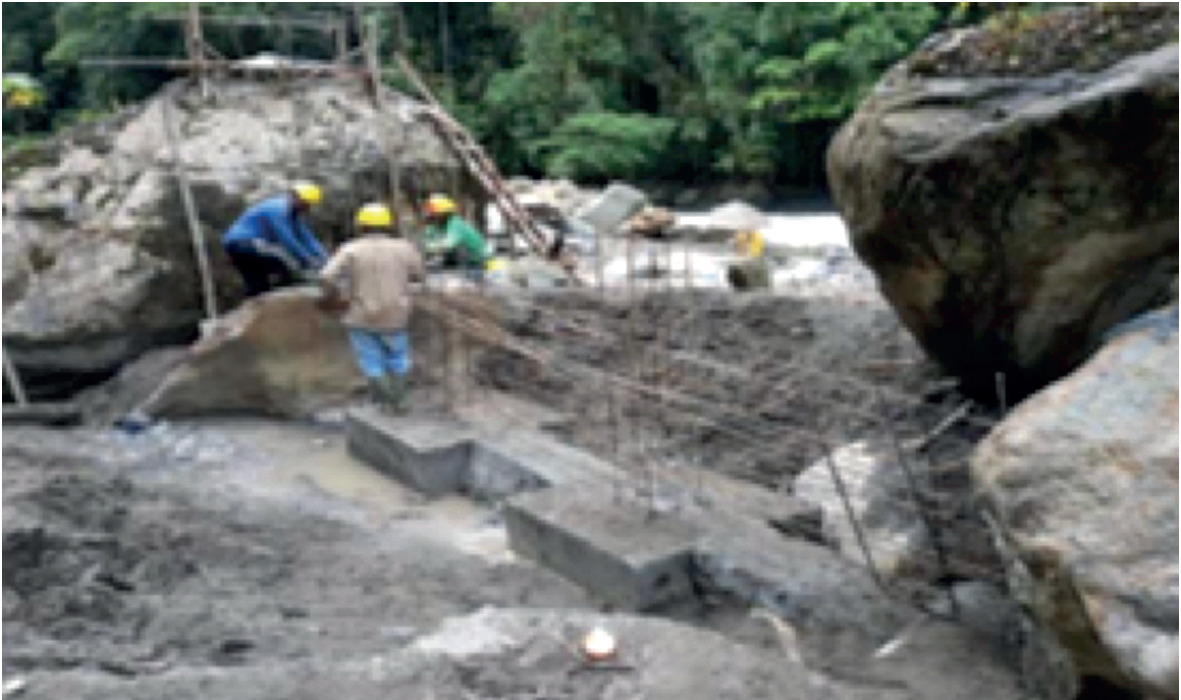 Pekerja sedang melakukan pemasangan dinding pada area intake, pembangunan PLTMH Oksibil, Papua, (September, 2020).