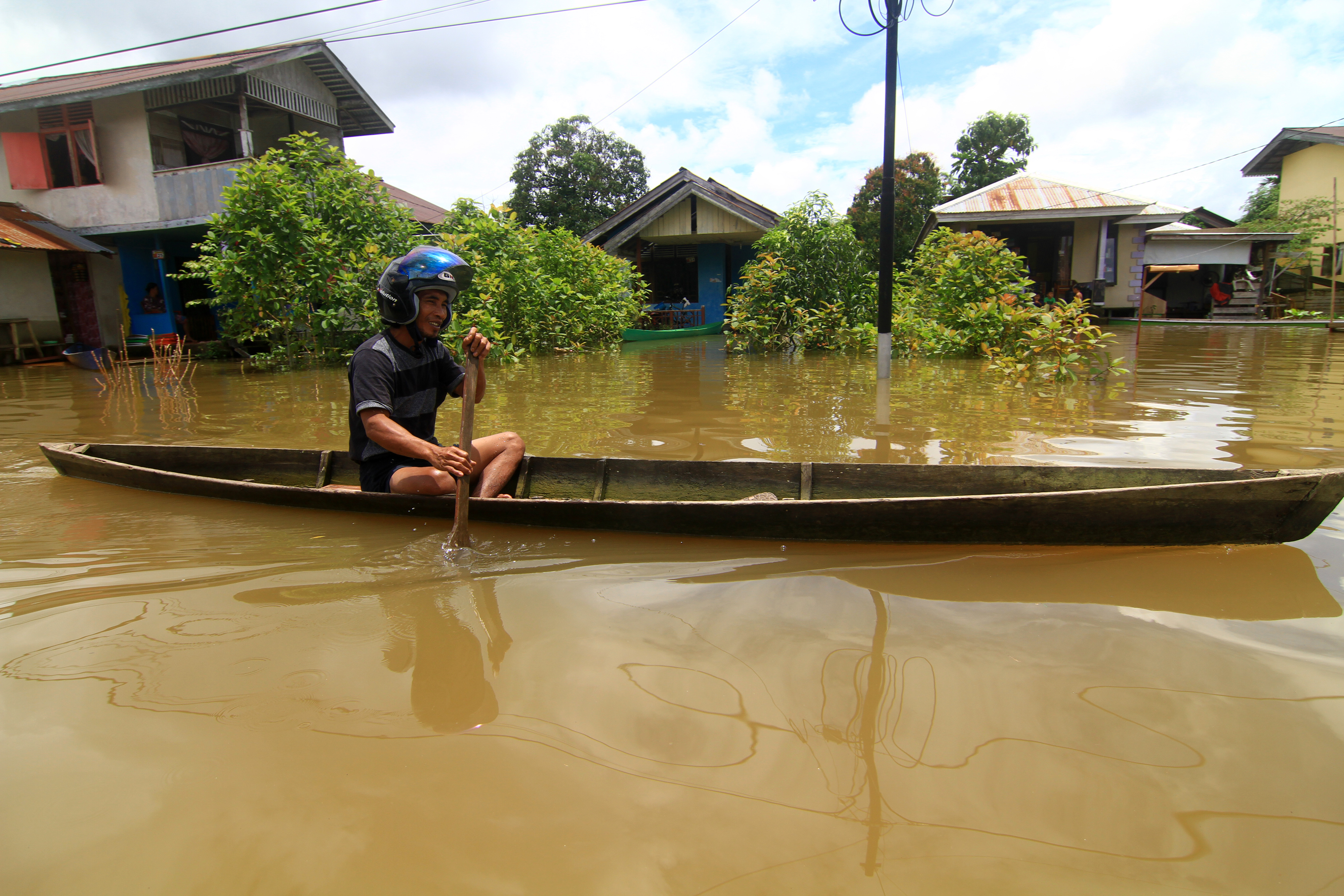 Seorang warga mendayung perahu saat melintasi banjir di kawasan Teluk Barak, Putussibau Selatan, Kapuas Hulu, Kalbar, Miggui (13/9).