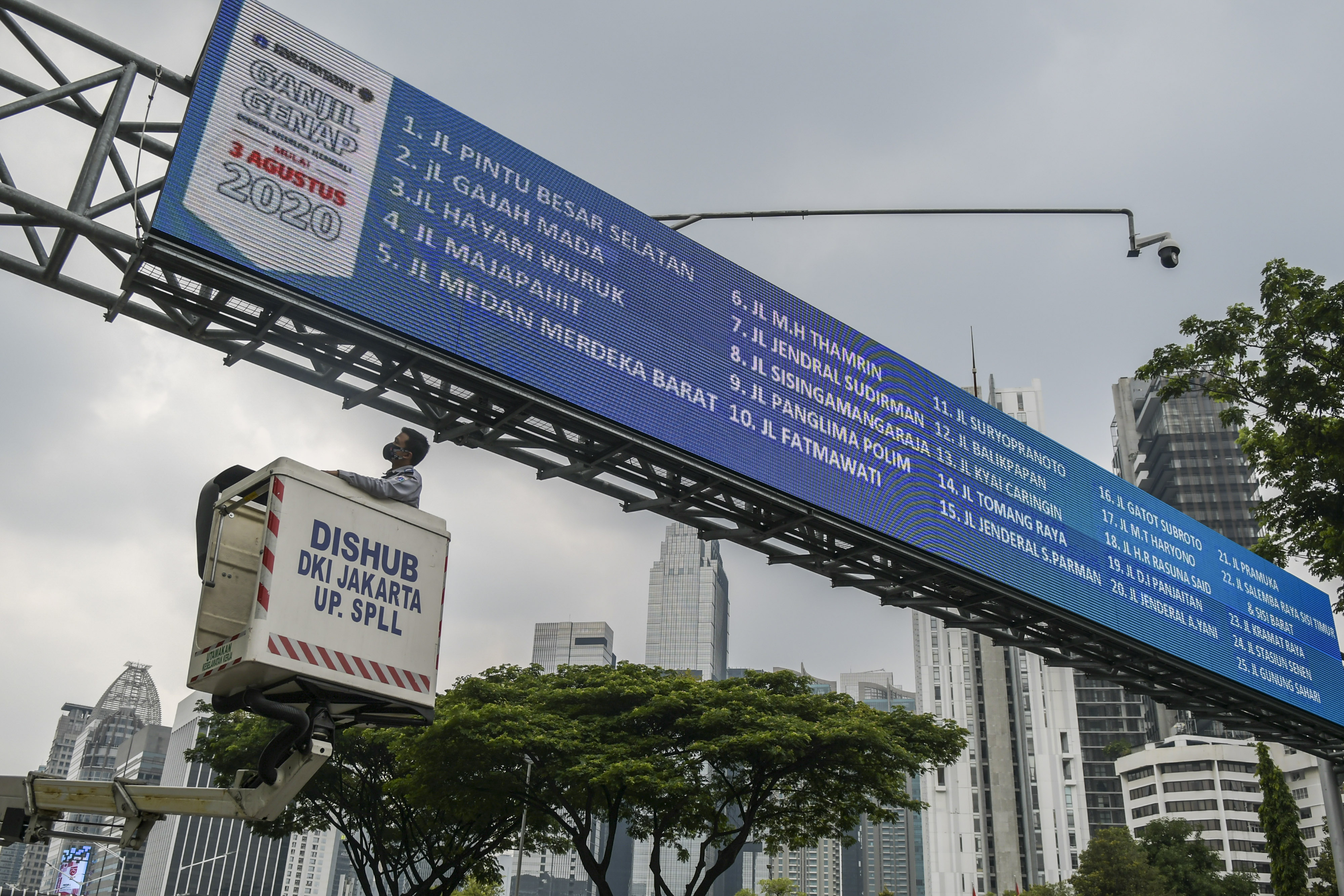 Petugas Dishub DKI mengecek papan informasi terkait sistem ganjil genap.