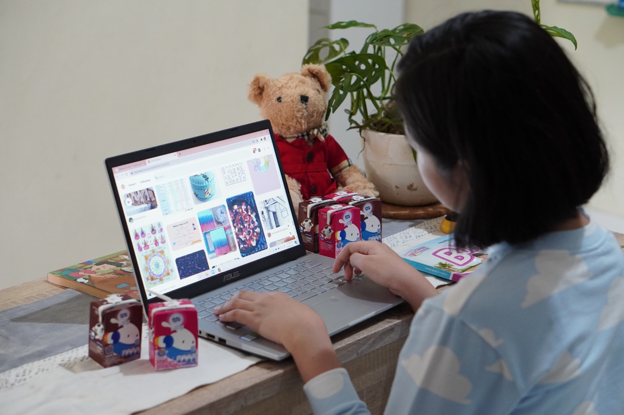 Seorang anak tengah belajar jarak jauh di rumahnya.