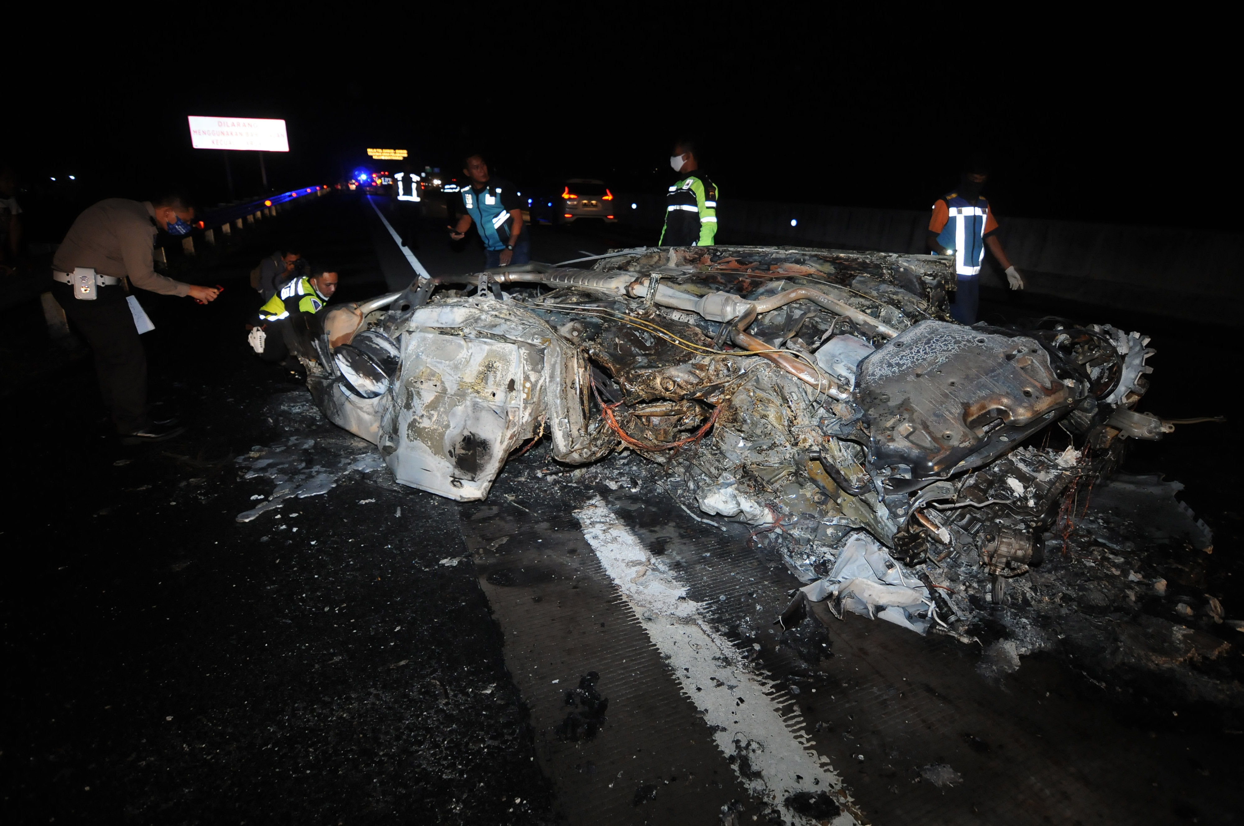 Sejumlah petugas melihat kondisi bangkai mobil yang terbakar karena kecelakaan, di jalan tol Kartasura-Boyolali, Boyolali, Jawa Tengah