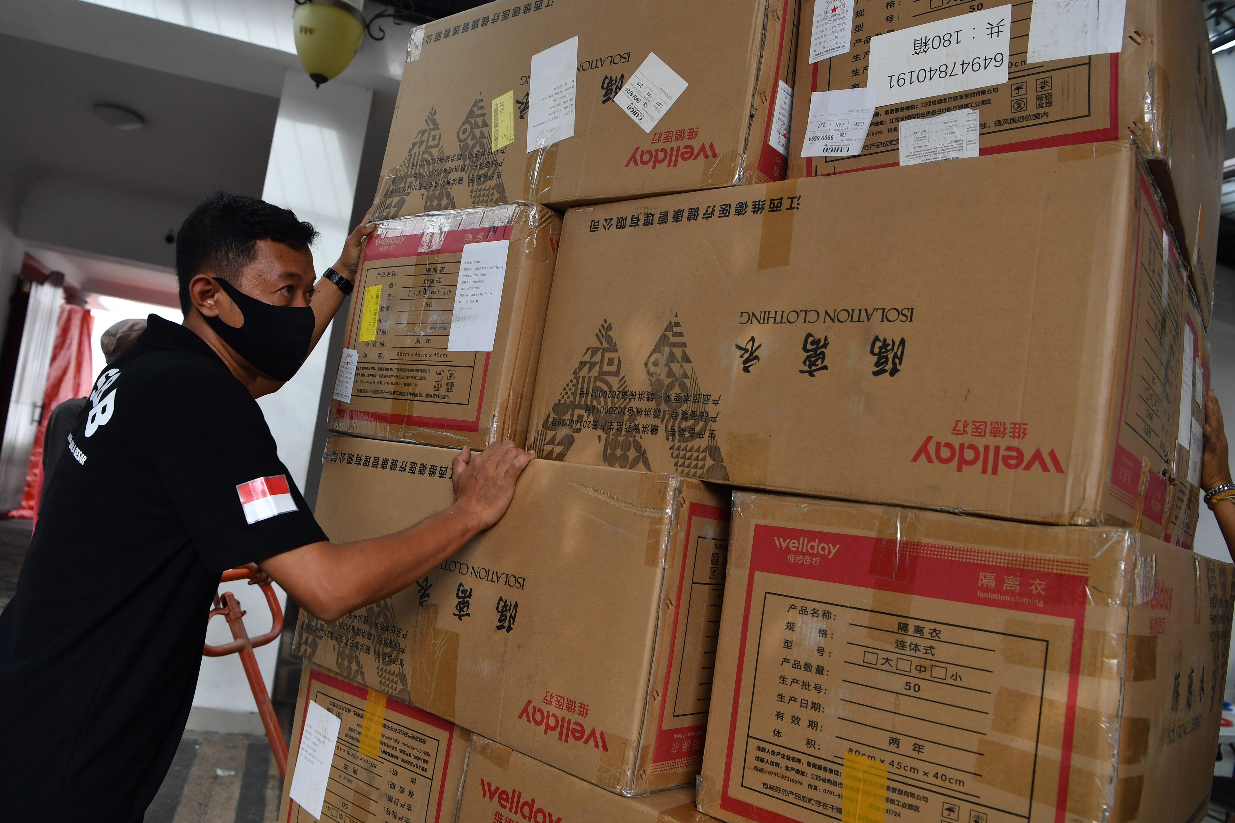 Pekerja menurunkan kardus berisi obat Avigan bantuan Kementerian BUMN di halaman Gedung Negara Grahadi, Surabaya, Jawa Timur.