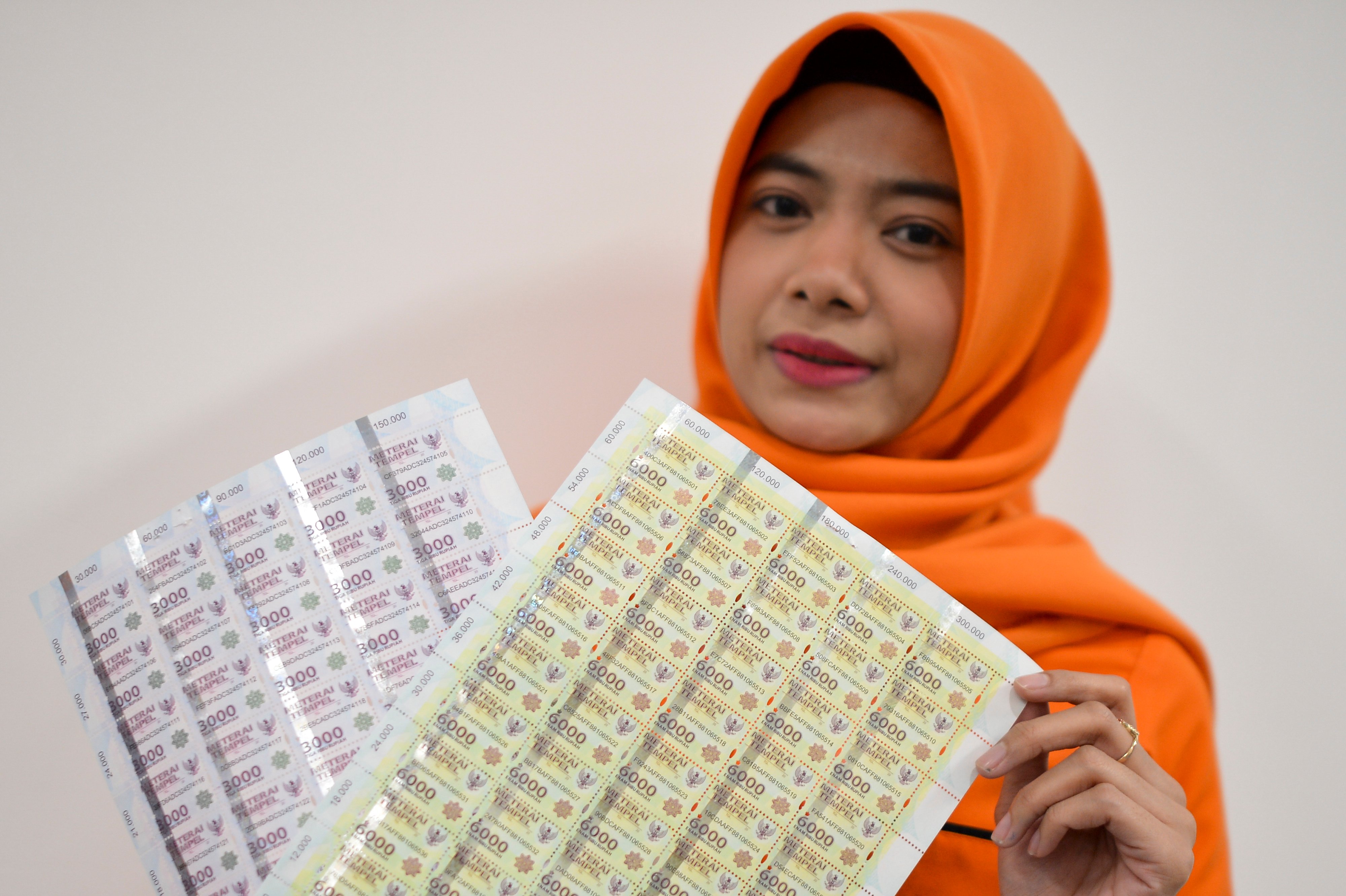 Karyawan menunjukan meterai di Kantor Pos Besar, Lapangan Banteng, Jakarta, Kamis (4/7/2019).