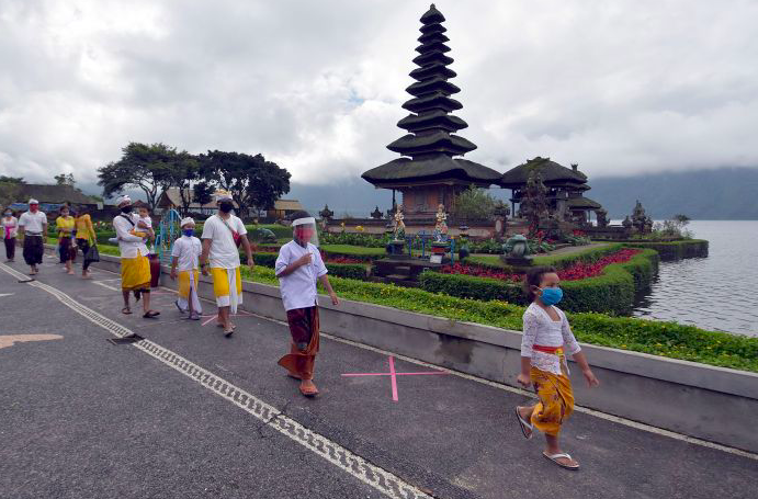 Sejumlah warga berjalan di pinggir danau saat turut berkunjung pada pembukaan obyek wisata Ulun Danu Beratan, Tabanan, Bali, pekan lalu. 