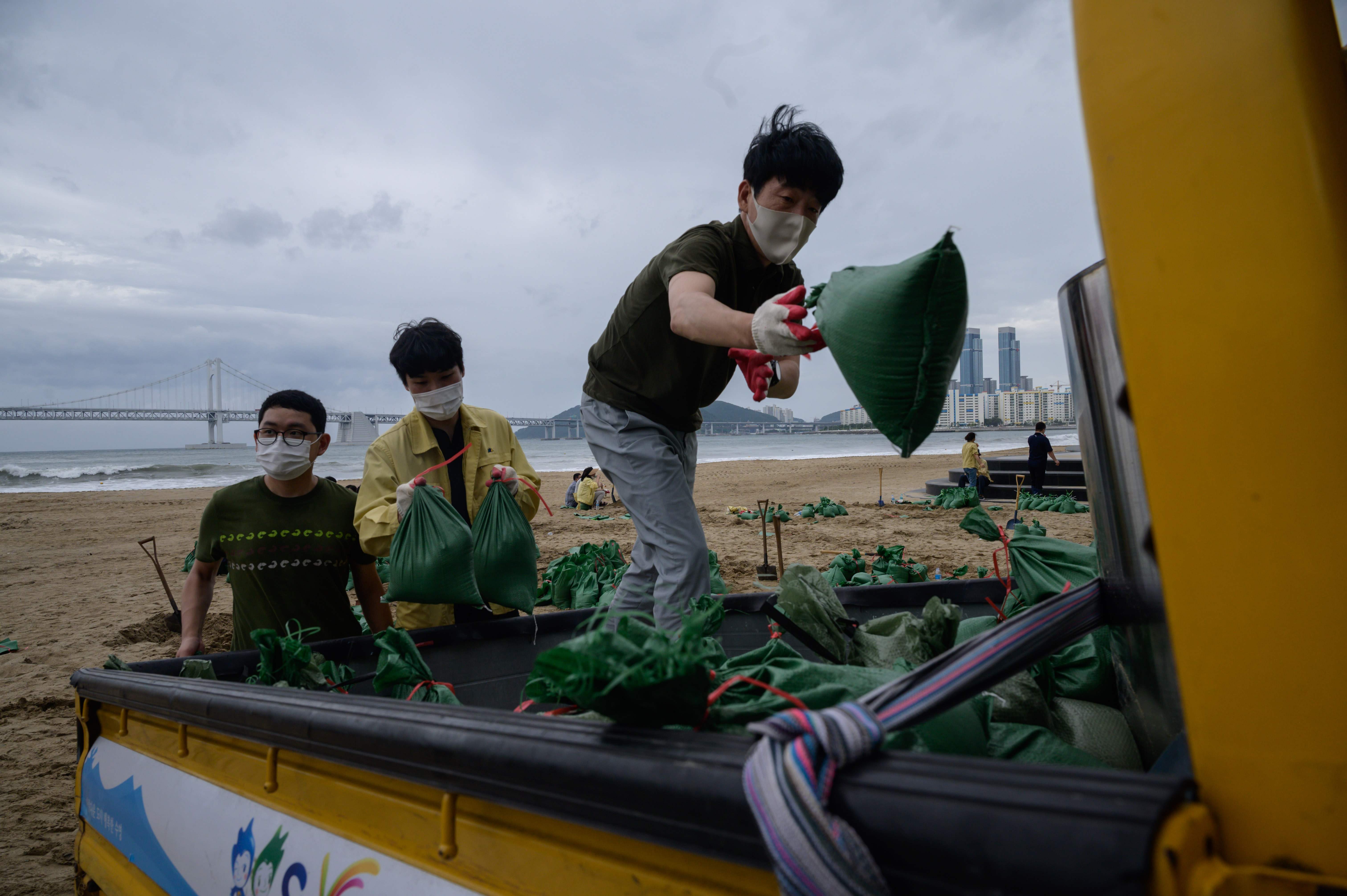 Petugas mengisi kantong pasir sebagai persiapan menjelang kedatangan topan Maysak, di pantai Gwangalli di Busan, KOrsel