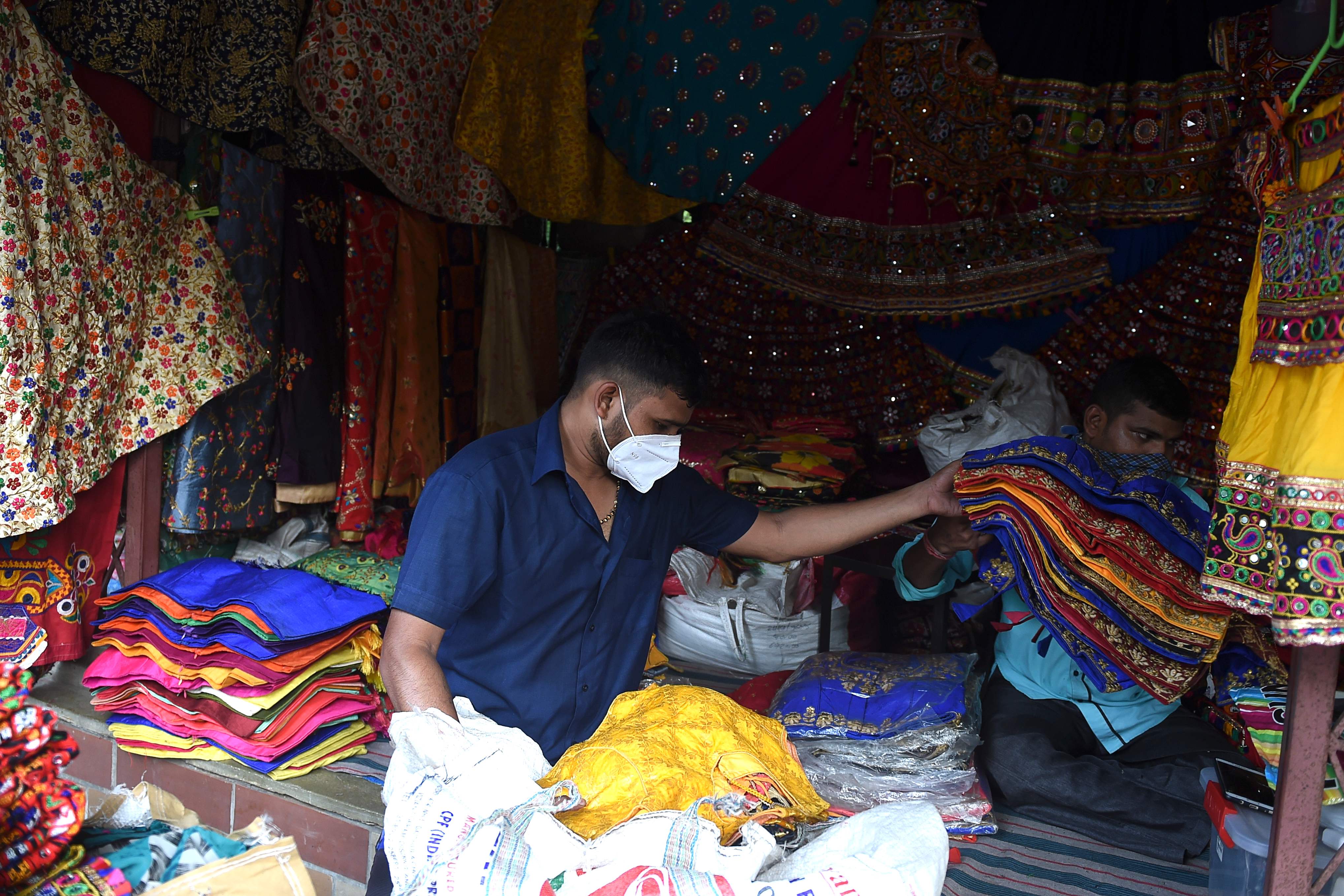 Seorang pedagang mengenakan masker di Law Garden Bazaar, Ahmedabad, India.