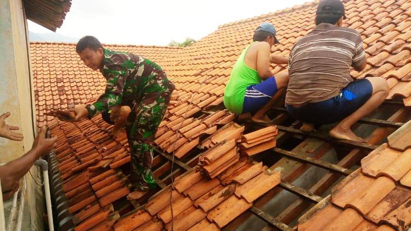 Hujan deras disertai angin kencang mampu menerbangkan genting rumah.
