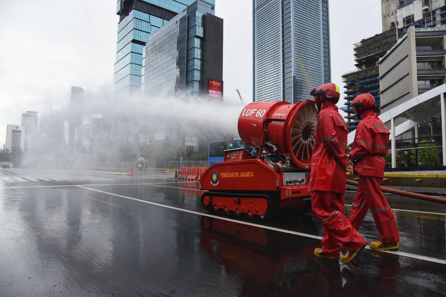 Petugas menyemprotkan cairan disinfektan menggunakan robot LUF 60 di sekitar kawasan Bunderan HI, Jakarta Pusat.