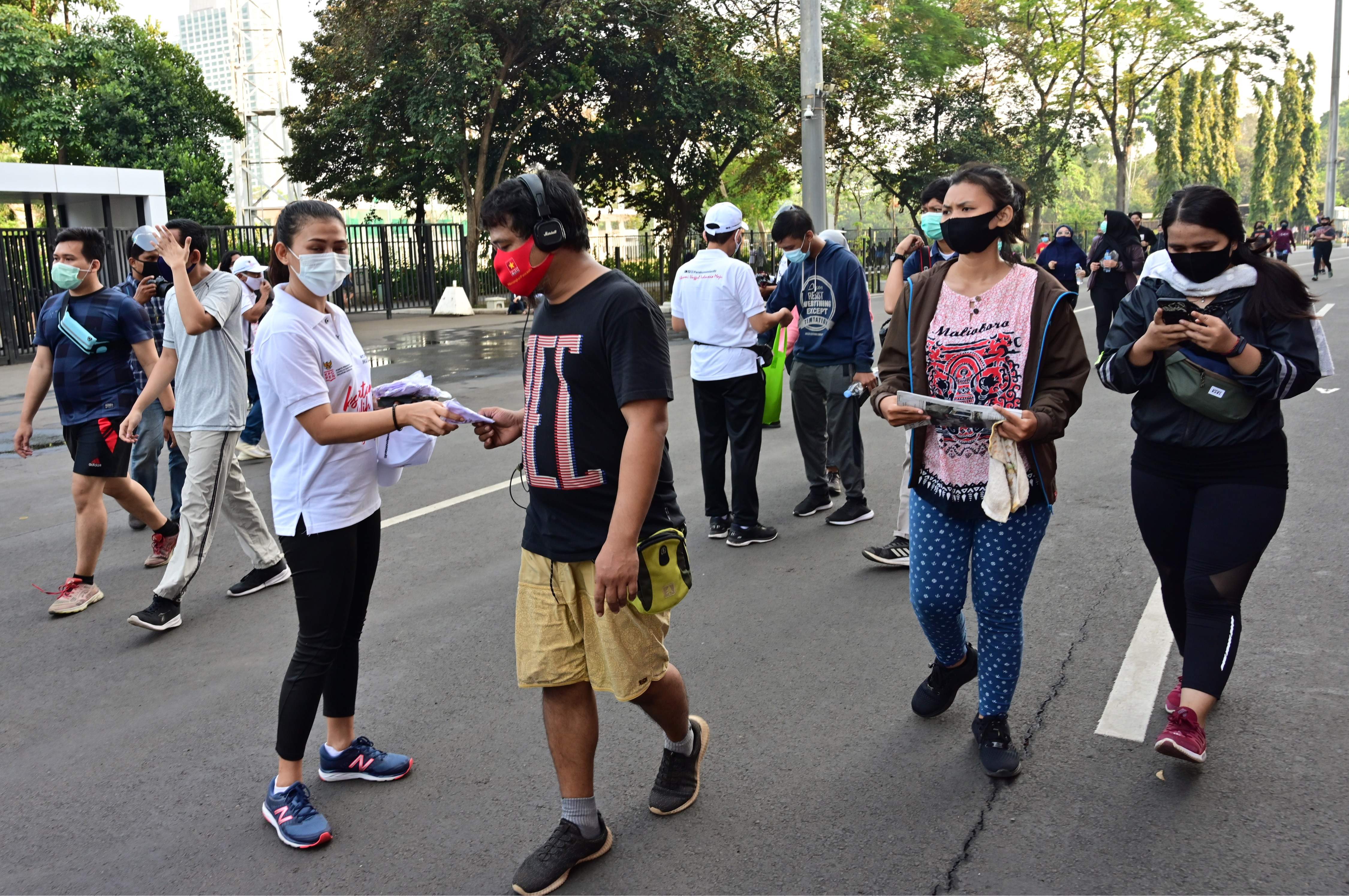 Seorang relawan membagikan masker di Gelora Bung Karno, Jakarta dalam rangka kampanye penggunaan masker untuk mencegah penyebaran covid-19.