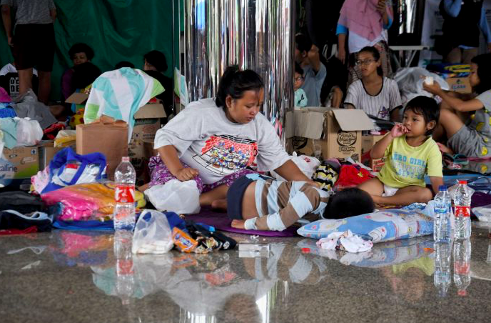 Warga terdampak banjir kawasan cipinang melayu tengah tidur dengan alas seadanya di pengungsian Universitas Borobudur. 