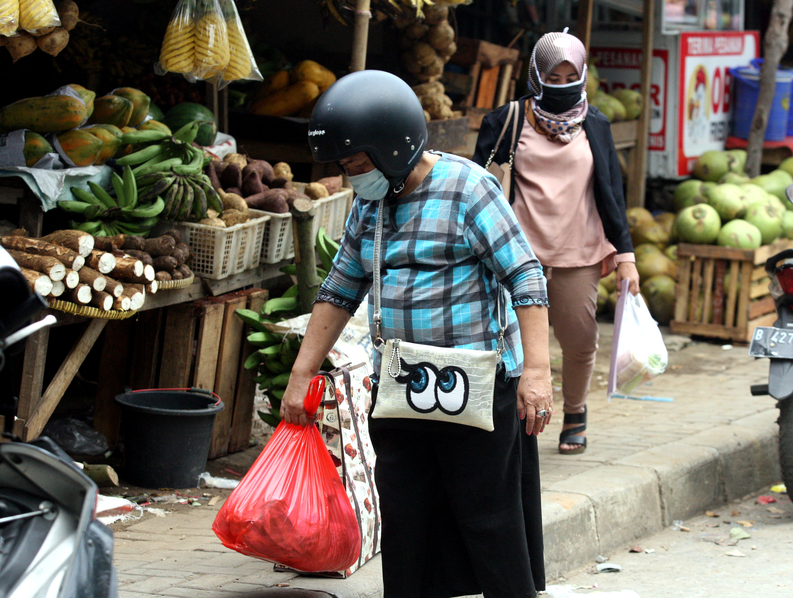 Warga berbelanja menggunakan kantong plastik sekali pakai di Pasar Cijantung, Jakarta, Rabu (12/8/2020)