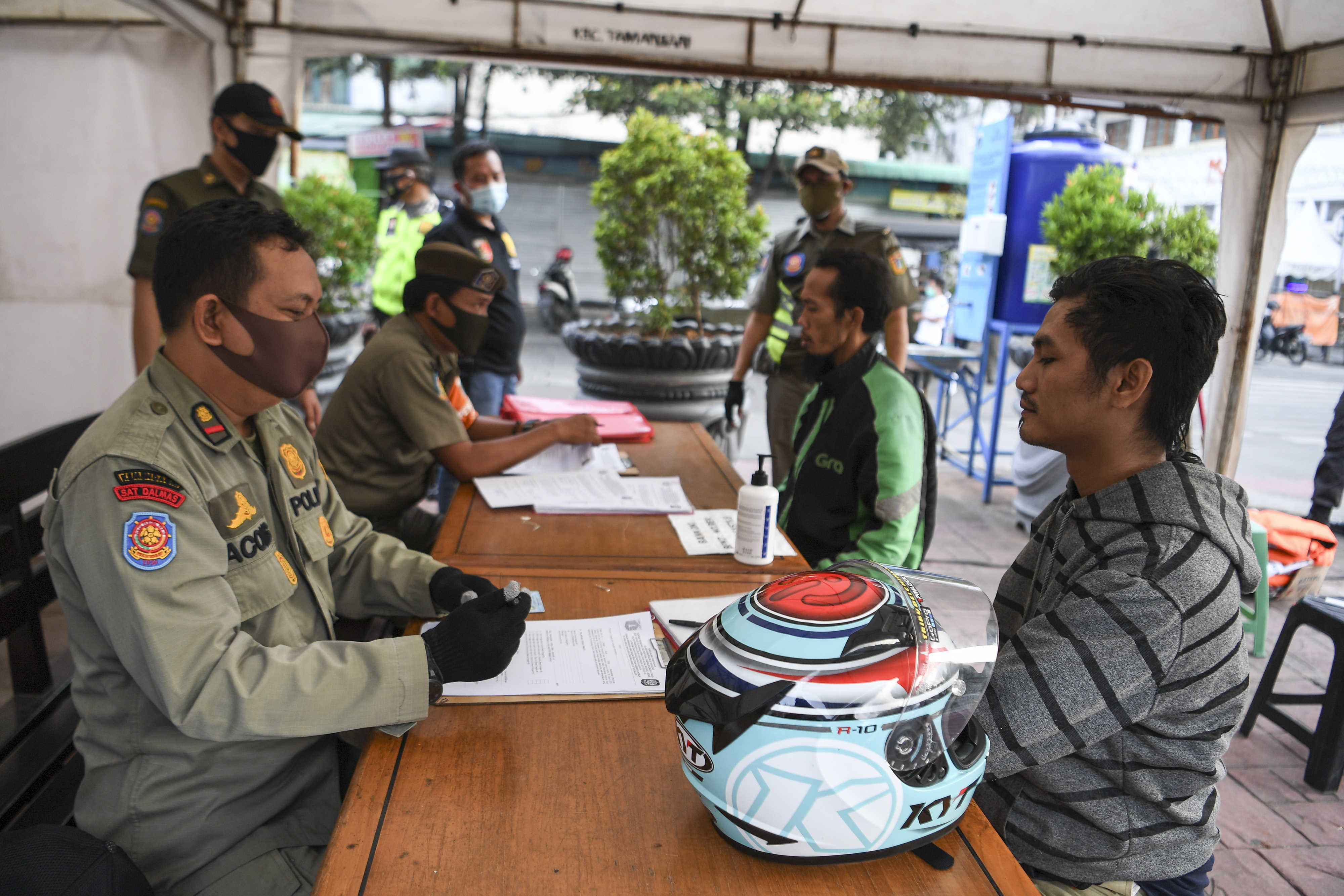 Warga yang melanggar aturan PSBB didata saat terjaring Operasi Tertib Masker di kawasan Kota Tua, Jakarta, Minggu (27/9).