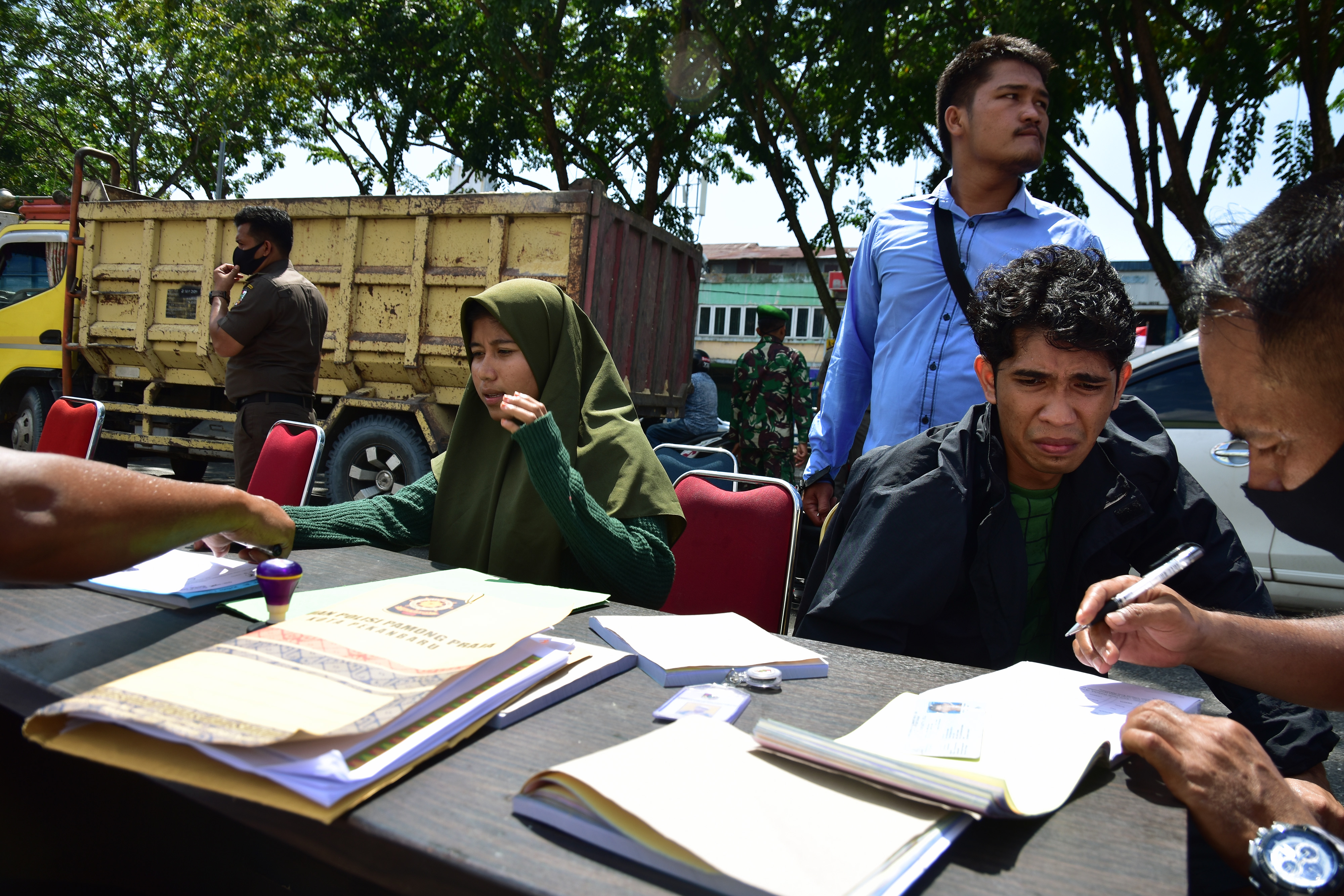 Sejumlah warga mengurus administrasi saat terjaring razia penerapan protokol kesehatan COVID-19 di Kota Pekanbaru, Riau, Senin (10/8/2020)