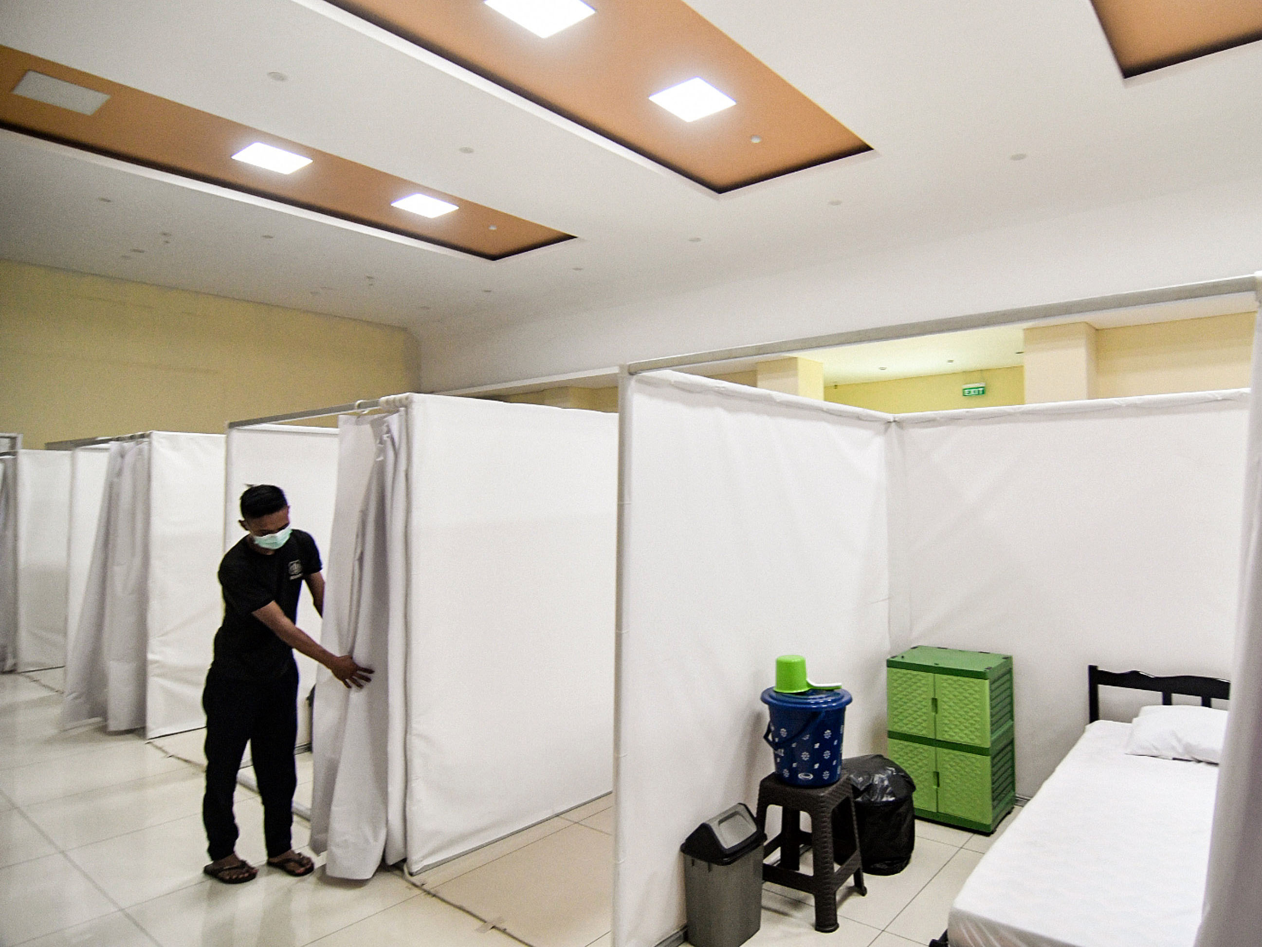Petugas merapikan bilik isolasi untuk pasien covid-19 di Gelanggang Remaja Kecamatan Pademangan, Jakarta Utara, Minggu (27/9