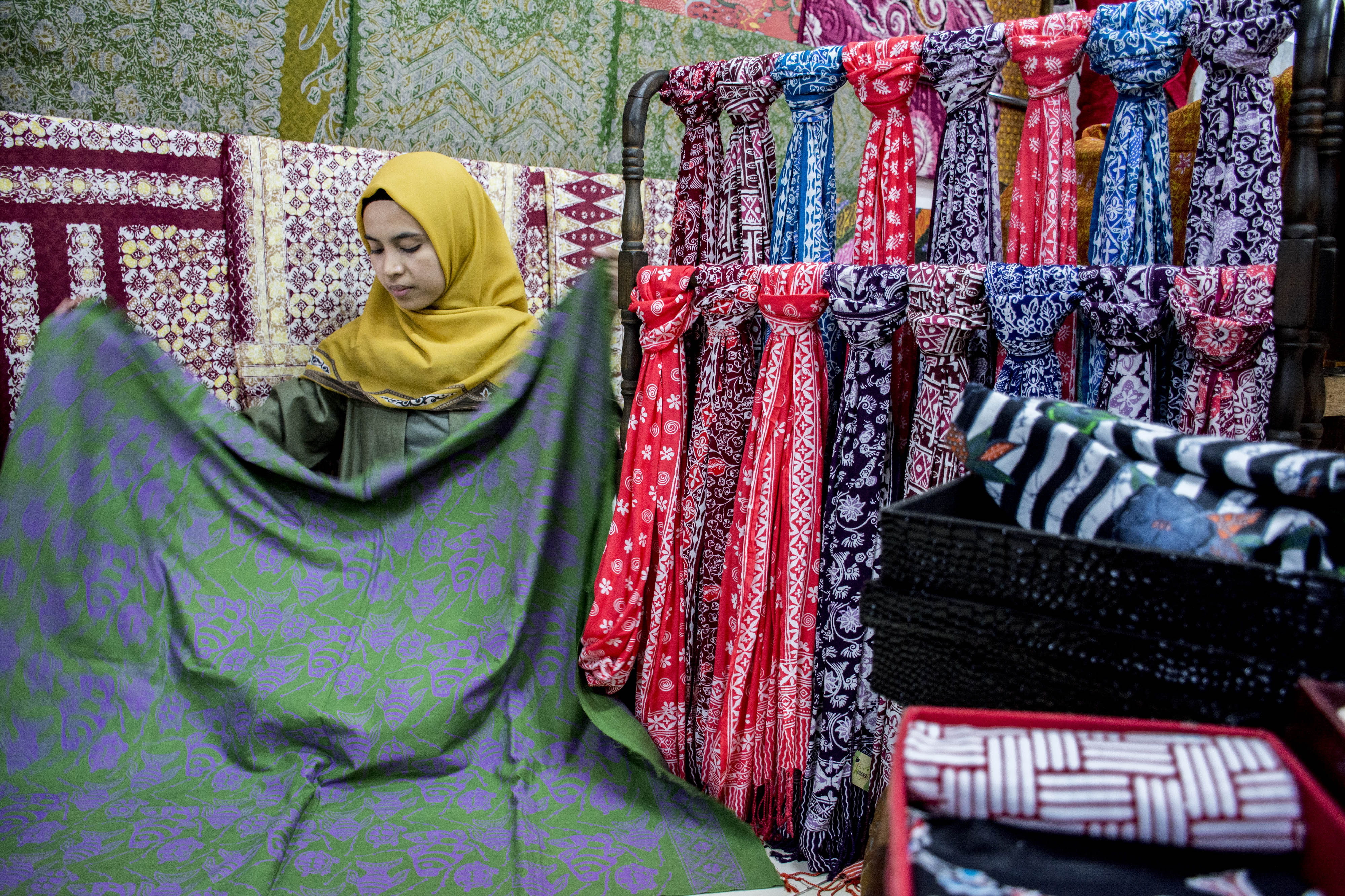 Pedagang menata batik di toko yang berlokasi di Sukabumi, Jawa Barat.