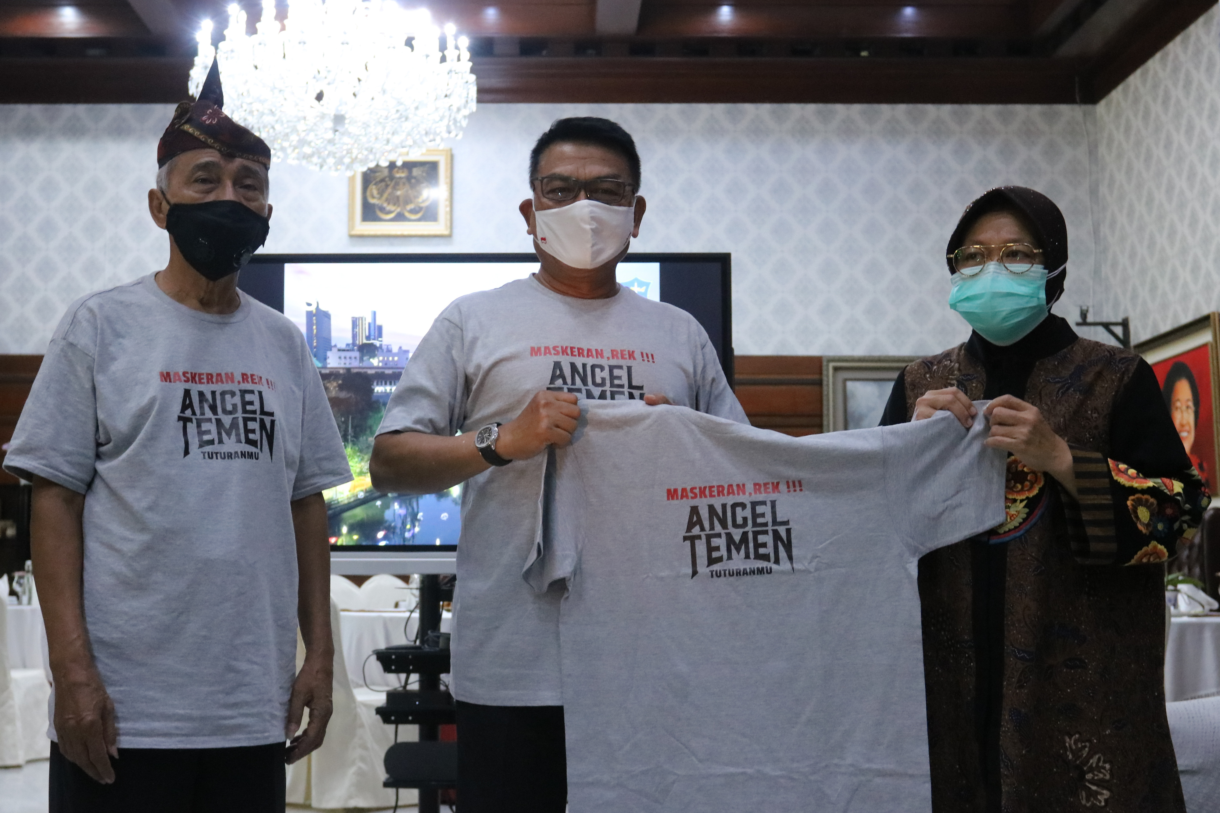 Kepala Staf Kepresidenan Moeldoko (tenga) memberikan kaus kampanye bermasker kepada Wali Kota Surabaya Tri Rismaharini di Surabaya, kemarin.