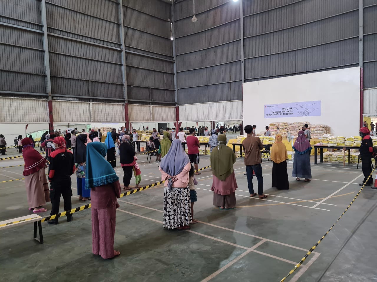 Masyakat antre untuk mendapat paket bantuan yang diberikan PT Gunung Raja Paksi Tbk (GRP).