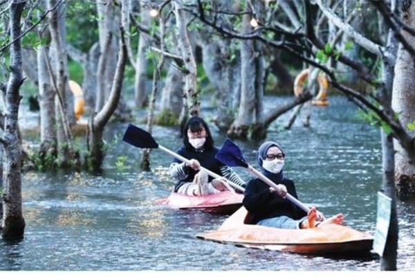Wisatawan bermain kano di Pantai Cacalan, Banyuwangi, Jawa Timur, kemarin.