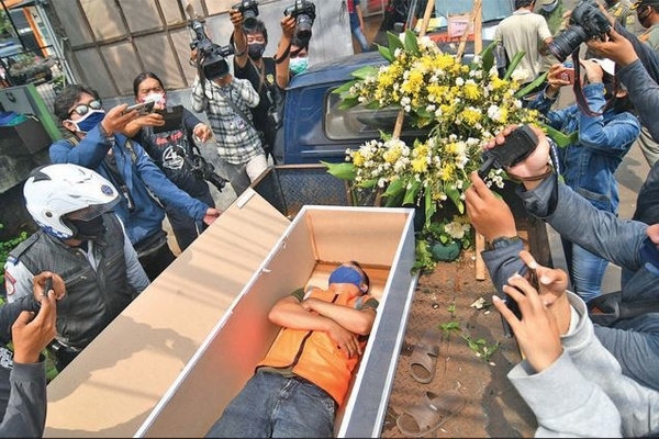 Warga yang melanggar protokol kesehatan dihukum masuk peti mati di Kalisari, Pasar Rebo, Jakarta