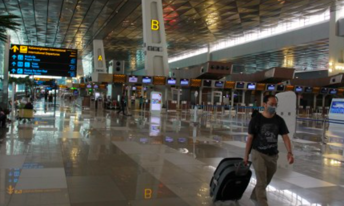 Calon penumpang WNA melintas di area keberangkatan Internasional yang terlihat lengang di Terminal 3 Bandara Soekarno Hatta, Tangerang.