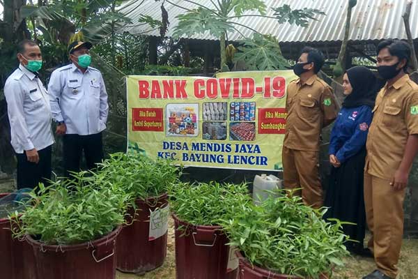 Para perangkat desa tengah meninjau Bank Covid-19 di Mendis Jaya, Kabupaten Musi Banyuasin, Sumatra Selatan, kemarin.