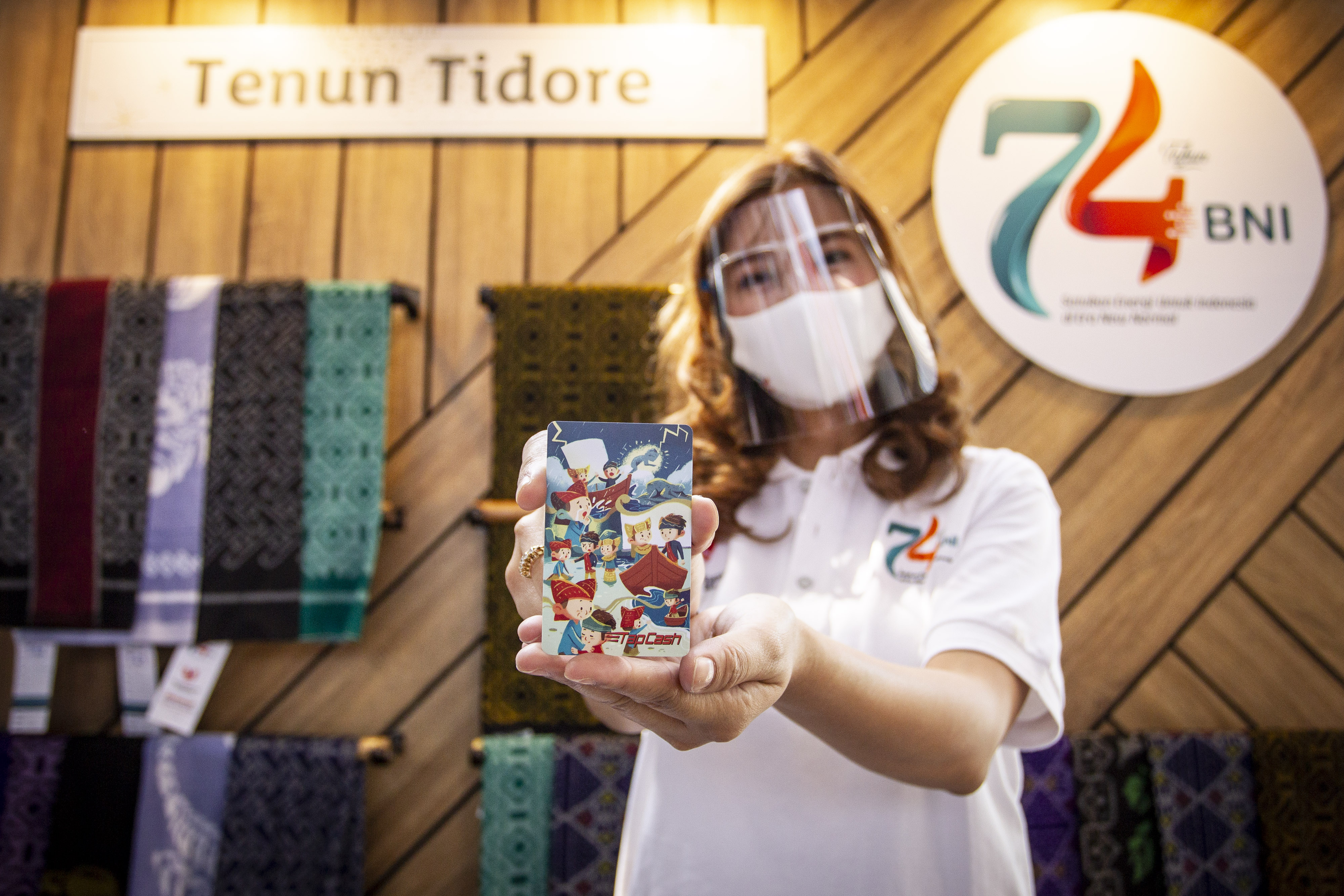  Karyawan menunjukkan TapCash BNI edisi khusus Kearifan Lokal pada Showcase Cinta Produk Nusantara di Lobby Grha BNI, Jakarta 