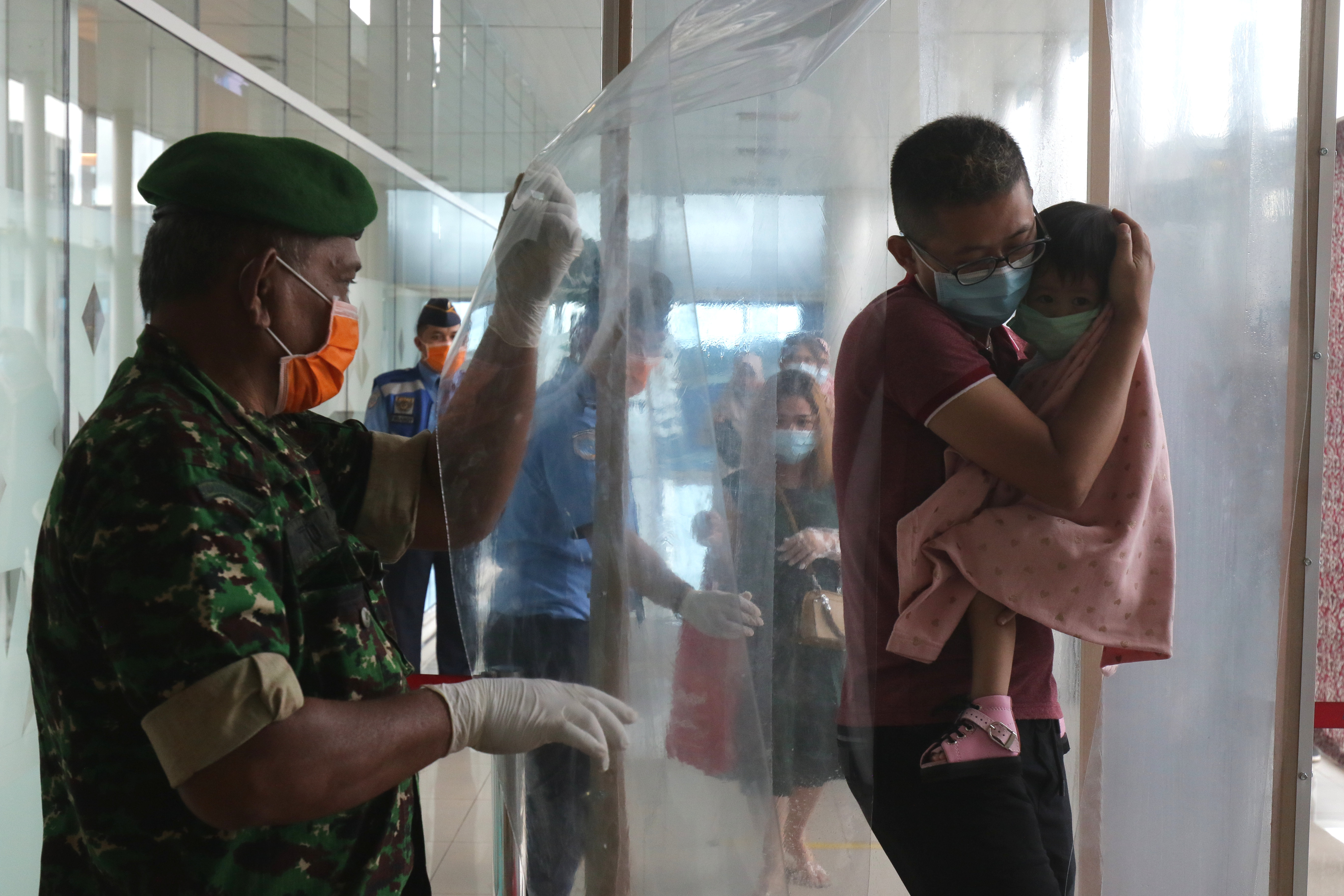 Calon penumpang berjalan keluar dari bilik disinfektan di terminal kedatangan Bandara Depati Amir, Pangkalpinang, Kepulauan Bangka Belitung.