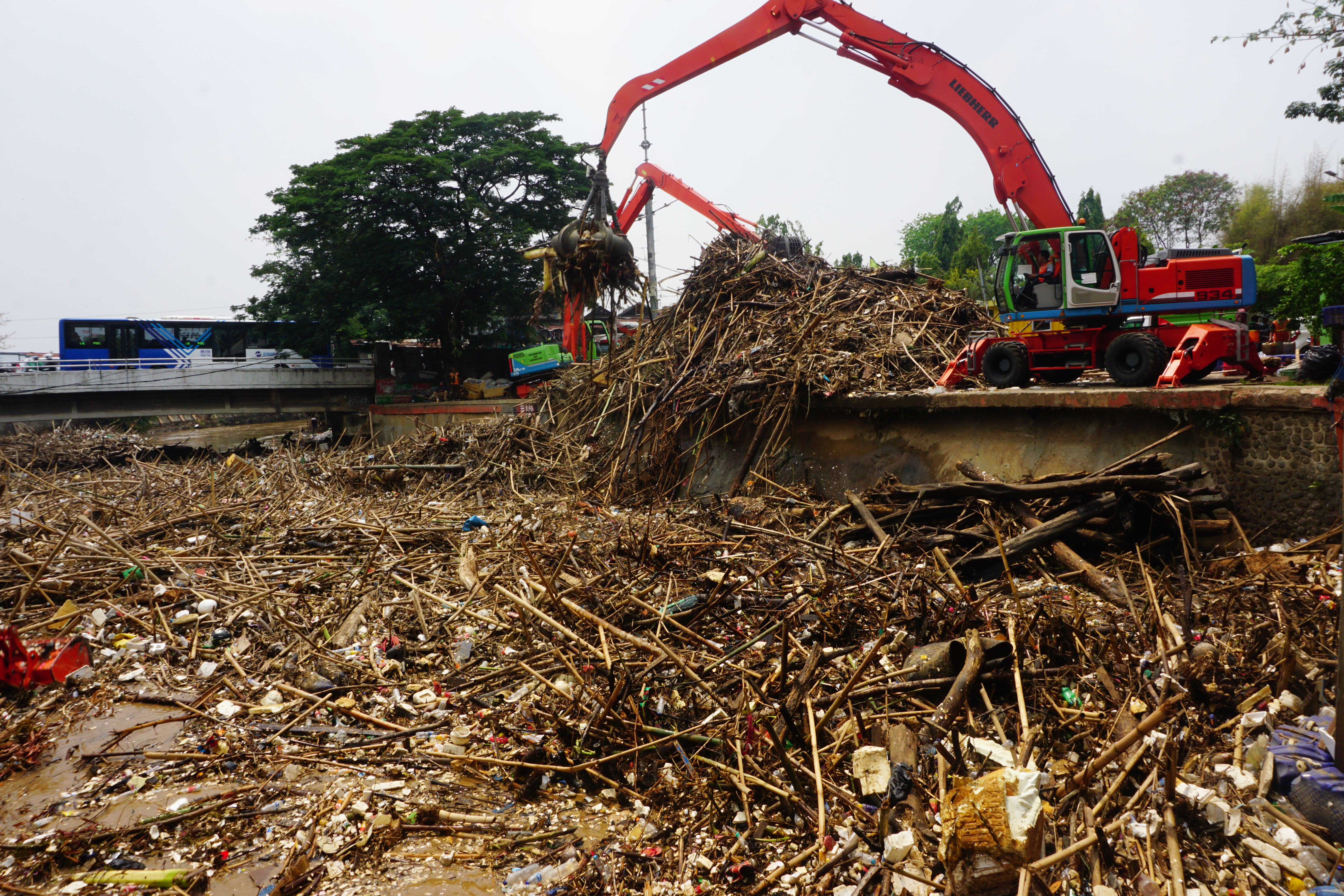 Sejumlah alat berat dikerahkan untuk mengangkut sampah di Pintu Air Manggarai, Jakarta Selatan.