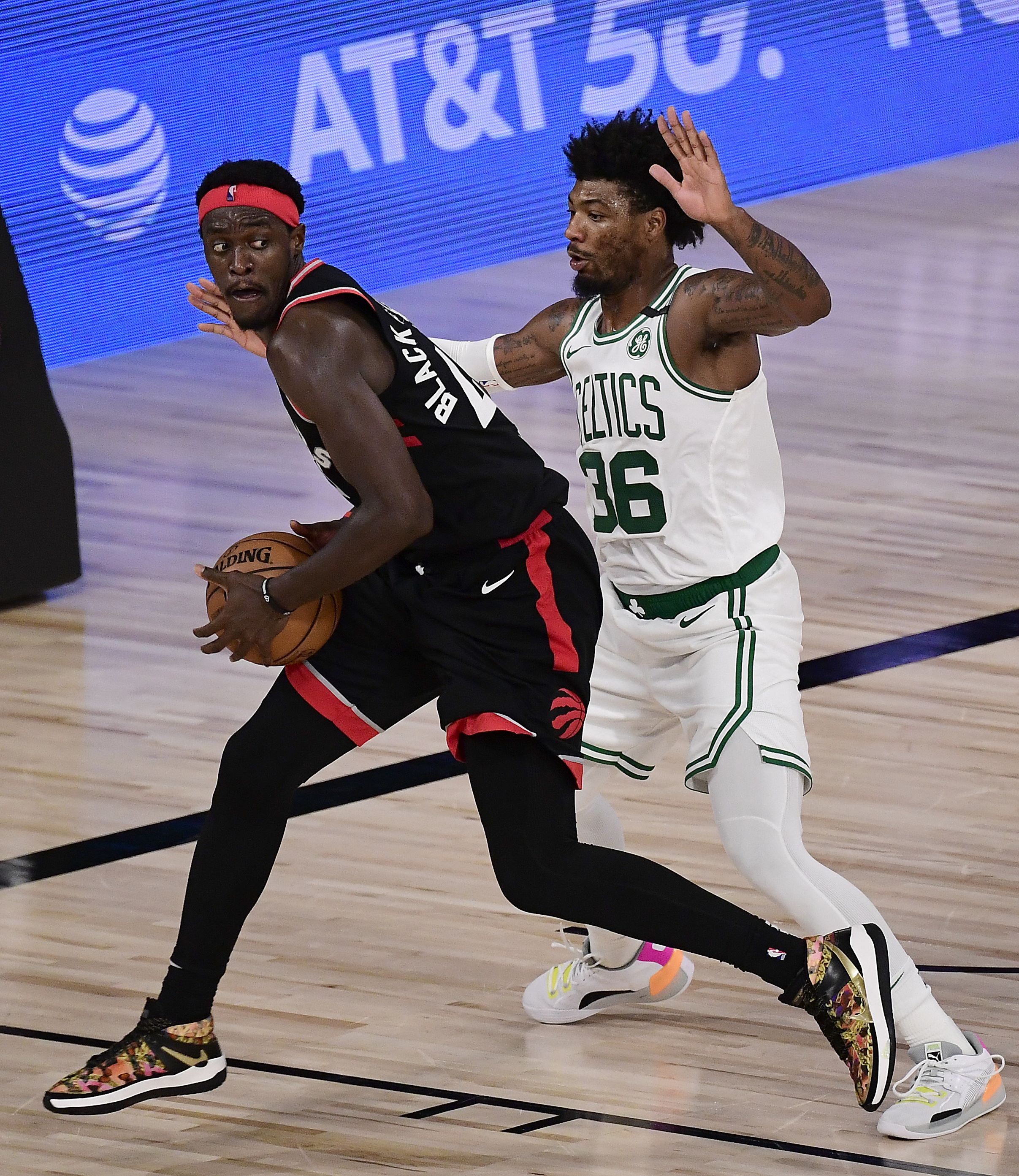  Pascal Siakam (depan/Toronto Raptors) berduel dengan Marcus Smart (Boston Celtics) dalam playoff NBA di Lake Buena Vista, Florida, AS (5/9)
