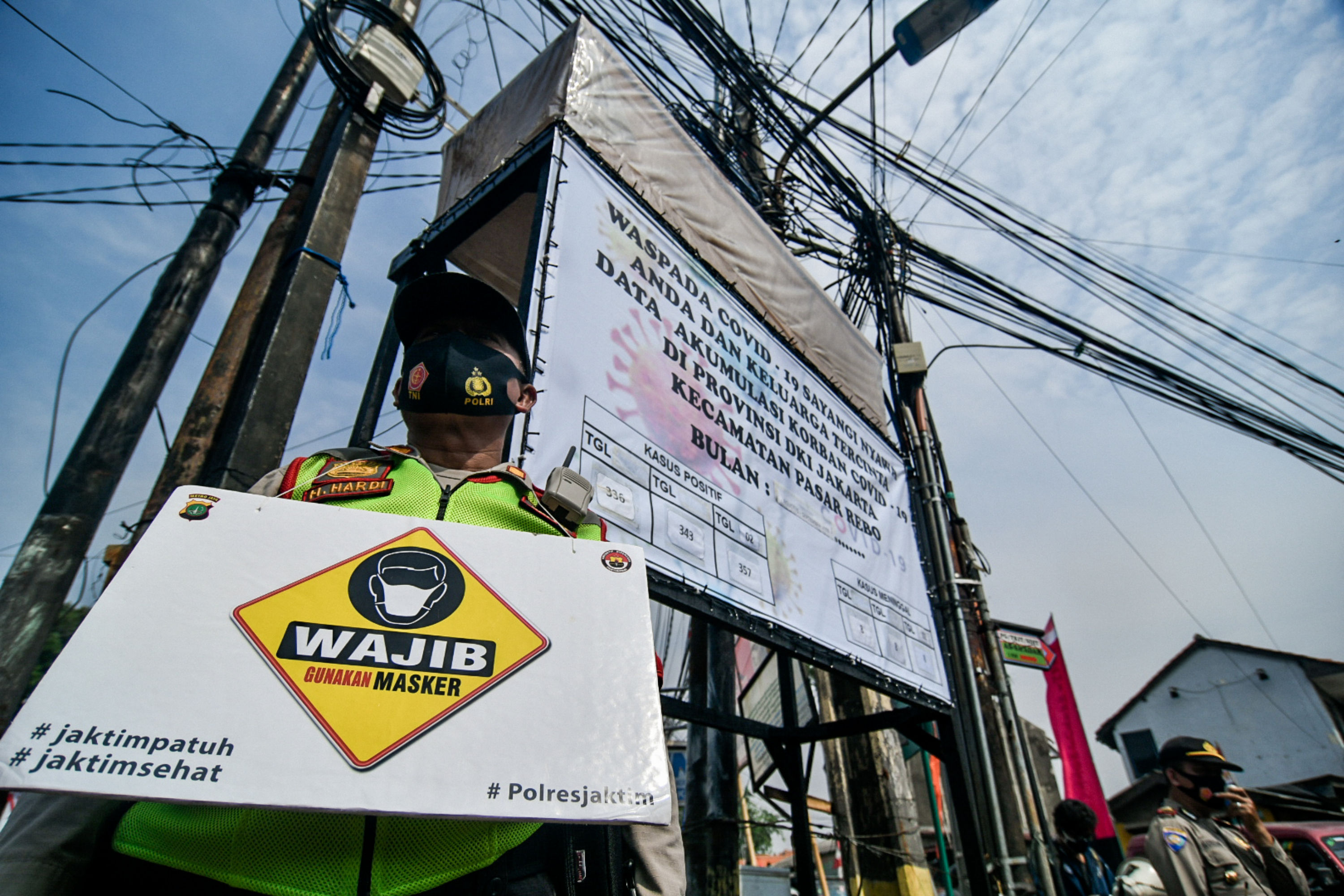 Petugas gabungan dari Kecamatan Pasar Rebo memberikan sosialisasi penggunaan masker di Kawasan Kalisari, Pasar Rebo, Jakarta Timur.