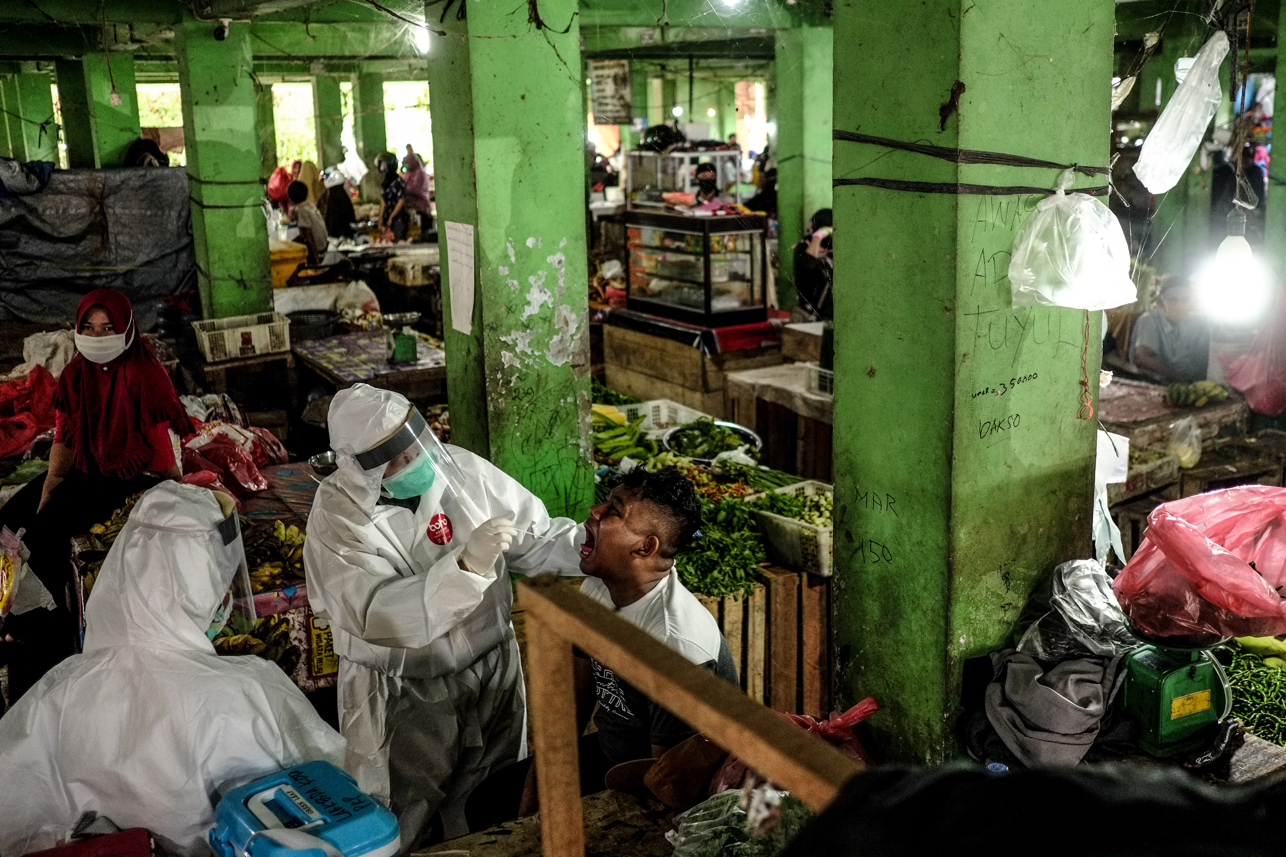Petugas mengambil sampel cairan dari hidung dan tenggorokan pedagang saat mengikuti swab test di Pasar Pagi, Kota Pangkalpinang.