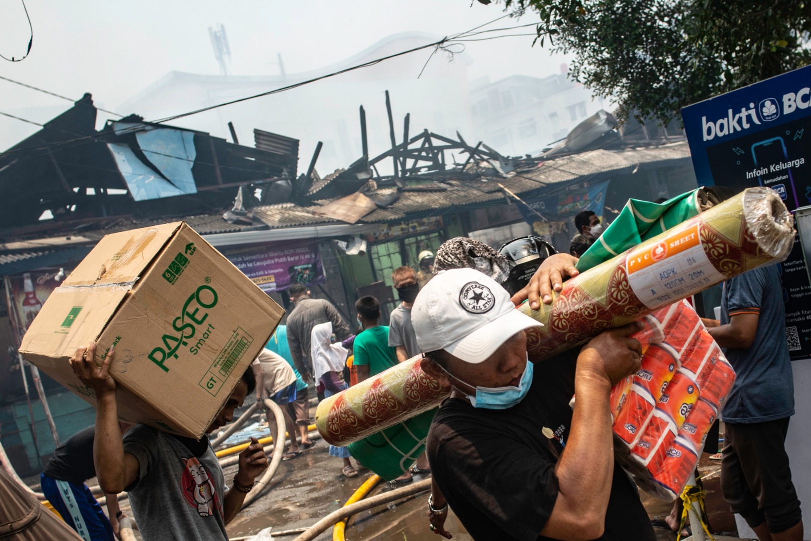 Pedagang mengevakuasi barang di tengah kebakaran yang melanda Pasar Cempaka Putih, Jakarta.