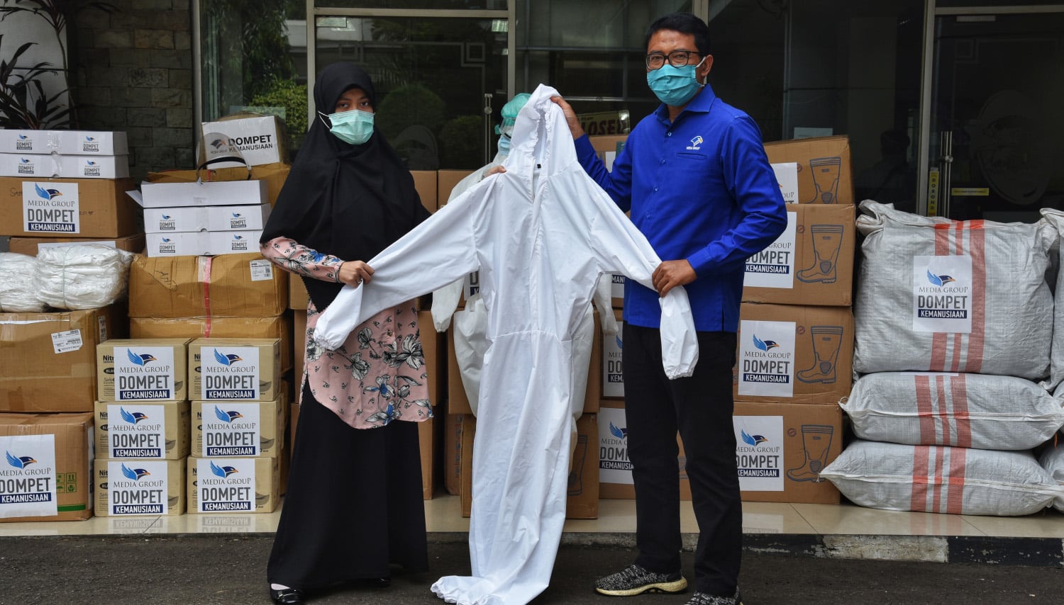  Ali Sadikin (kanan) menyerahkan bantuan alat pelindung diri (APD) kepada Ketua Gerakan Co-Hope, Yosilia Nursakina, di lobi Gedung Metro TV,