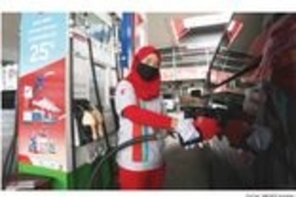 Salah seorang petugas SPBU Pertamina memberikan pelayanan pengisian BBM dengan menjalankan protokol kesehatan di kala pandemi Covid-19.