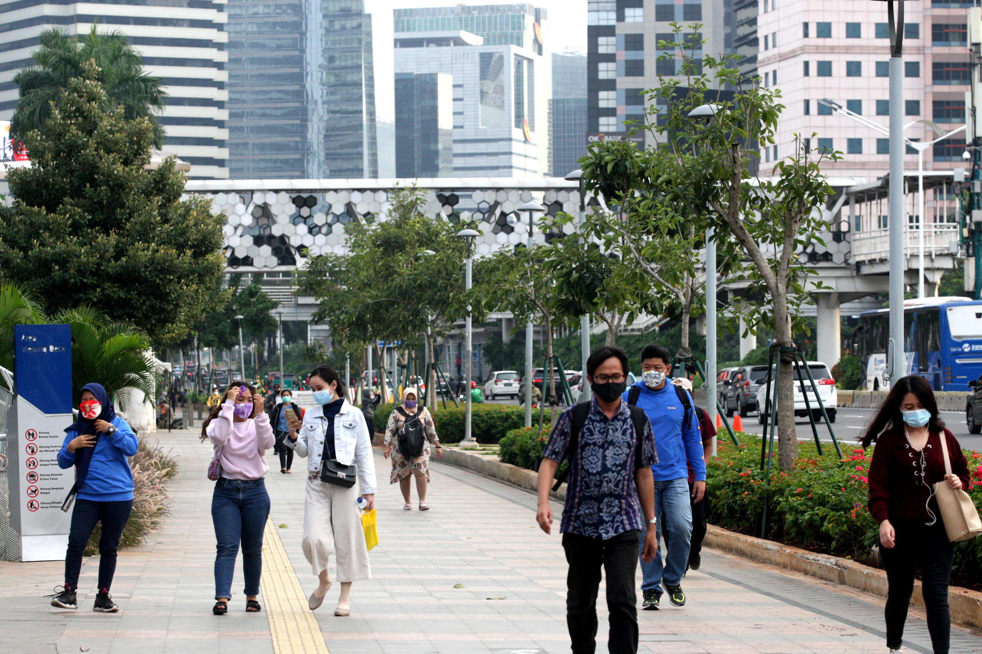 Pekerja berjalan pulang dari kantor mereka di kawasan Sudirman, Jakarta, Jumat (25/9/2020)