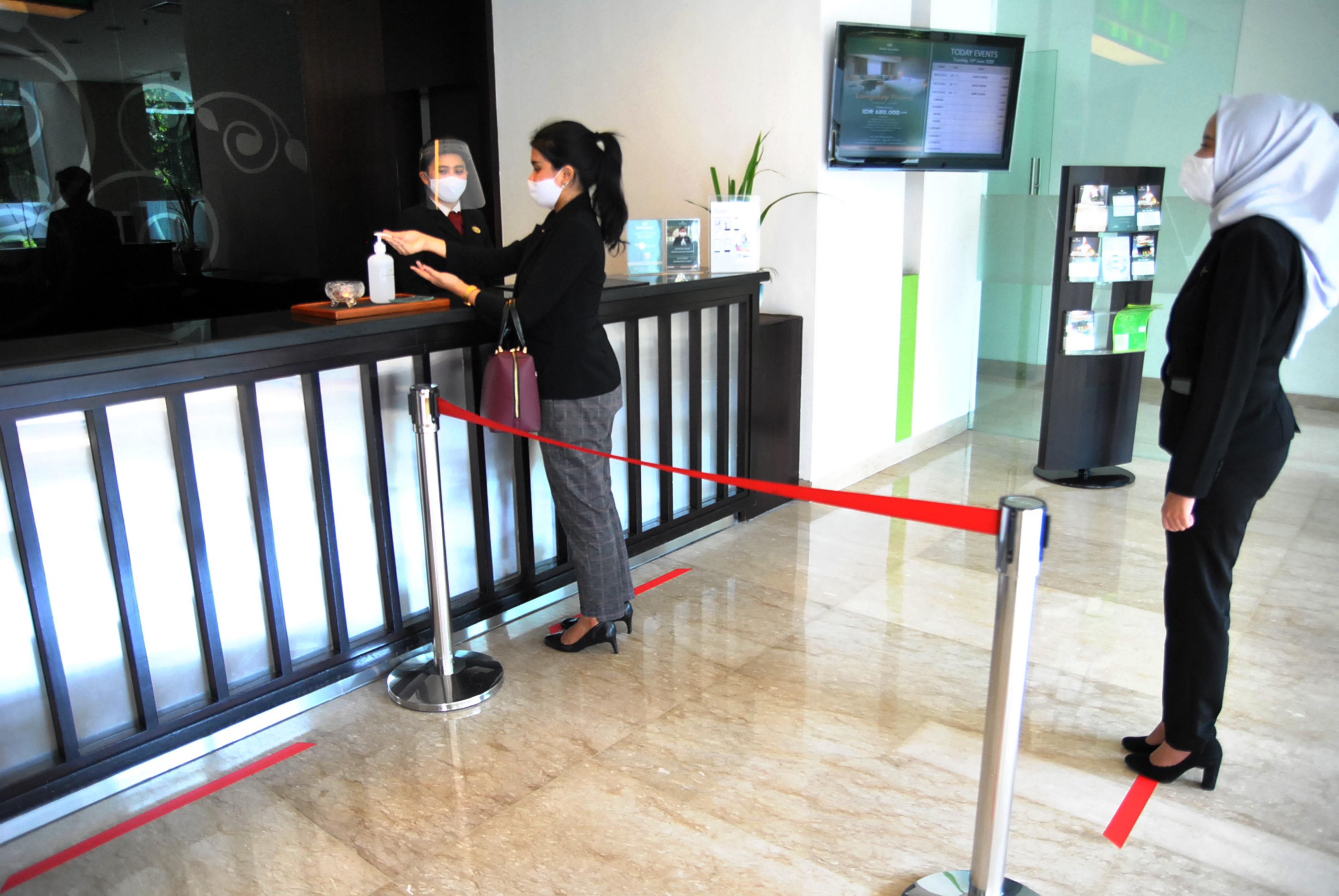 Tamu hotel antre dengan jaga jarak fisik di Hotel Santika, Kota Bogor, Jawa Barat, Selasa (16/6).