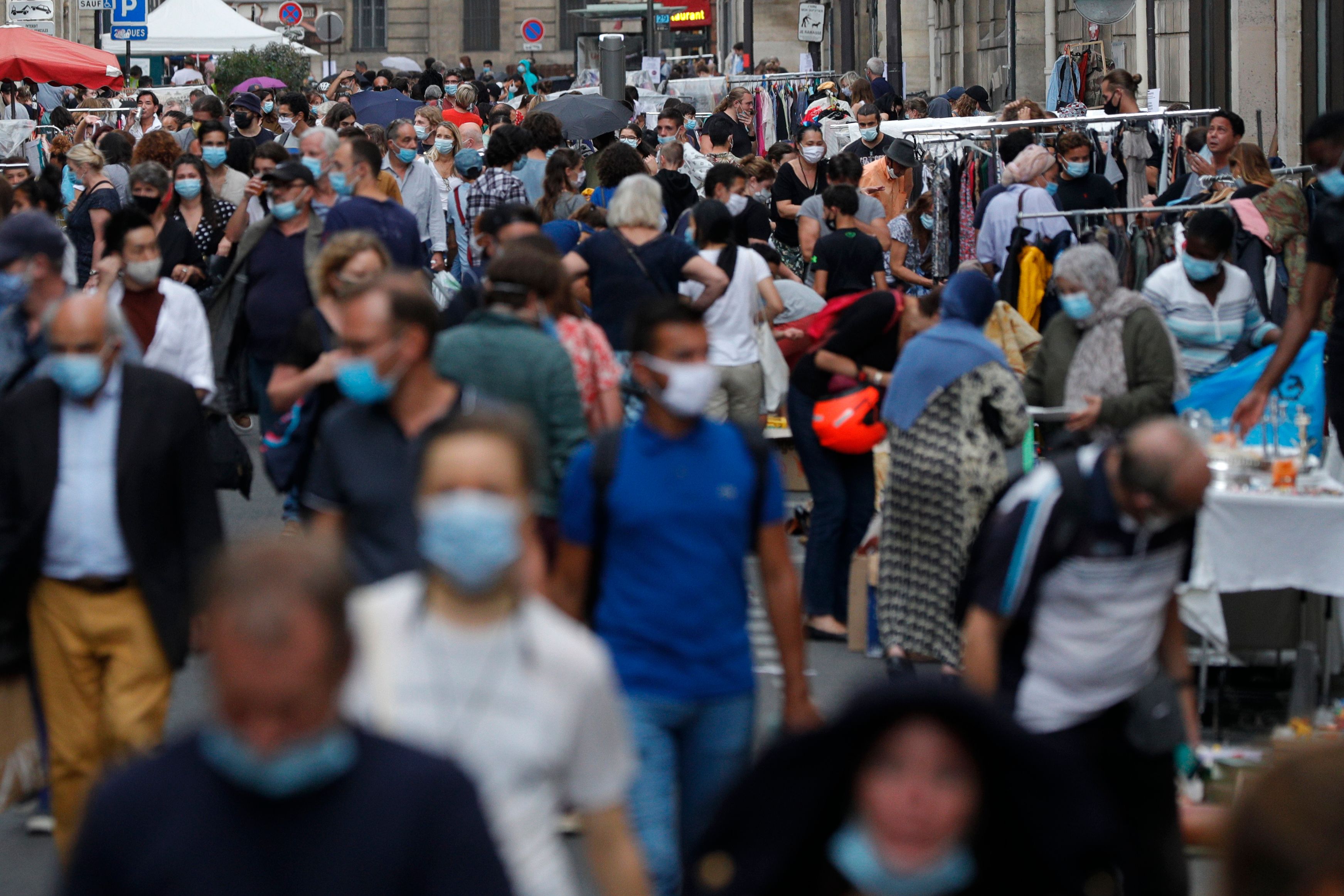Warga yang mengenakan masker melakukan aktivitas di sebuah pasar loak di Paris, Prancis.