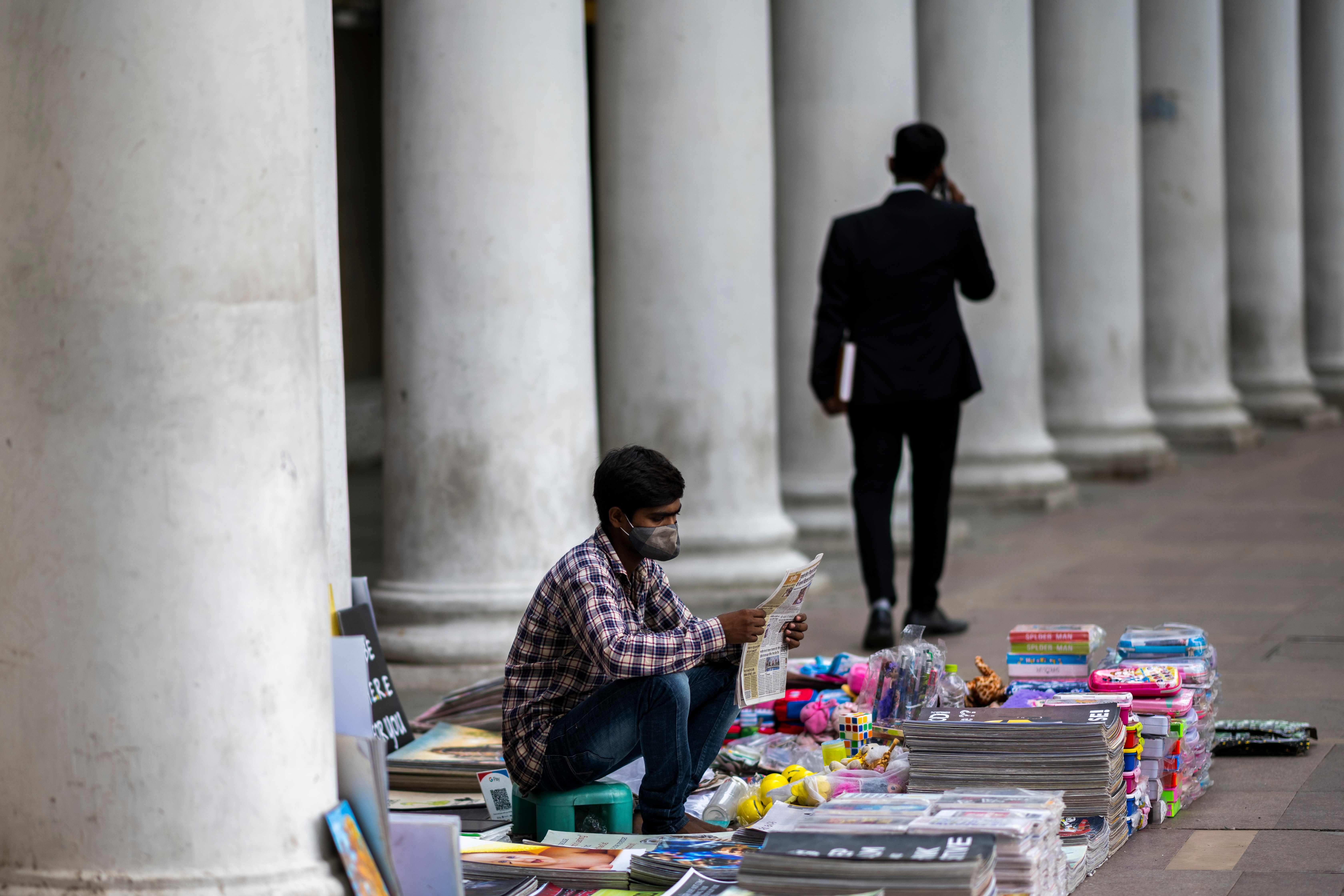 Seorang pedagang buku dan majalah di India mengenakan masker agar tidak tertular virus korona.