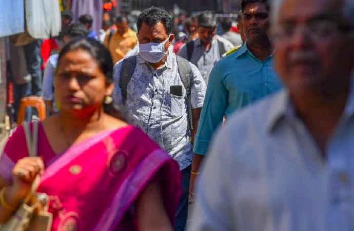 Pengguna kereta api menggunakan masker di tengah kekhawatiran virus covid-19 di luar sebuah stasiun di Mumbai, India.  