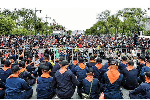AKSI MENENTANG MONARKI: Polisi duduk di depan pengunjuk rasa antipemerintah  dalam unjuk rasa prodemokrasi di Bangkok, Thailand, kemarin. 