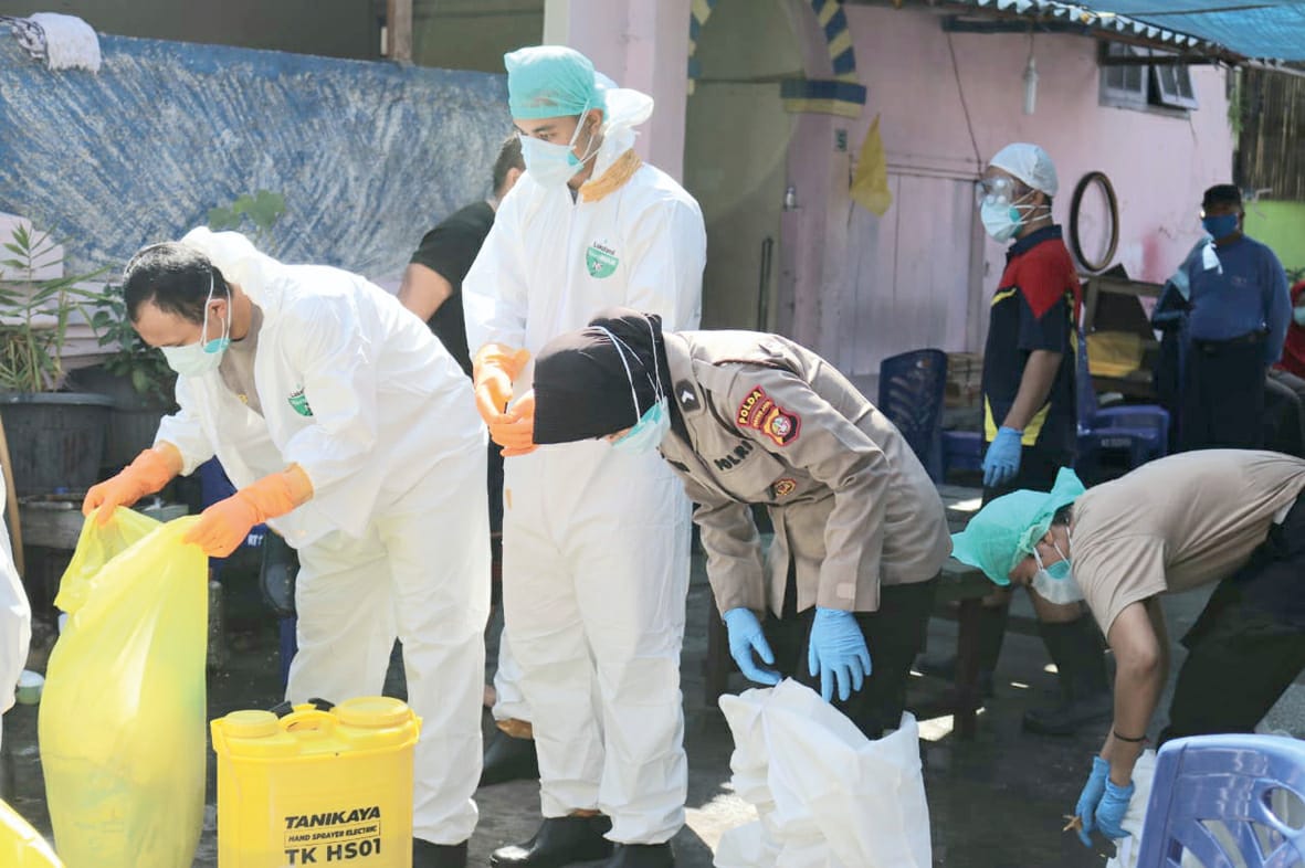 Timsus Direktorat Samapta Polda Metro Jaya (PMJ) memulasarakan dua jenazah pasien Covid-19 di TPU Tegal Alur, Jakarta Barat, Sabtu (16/5).