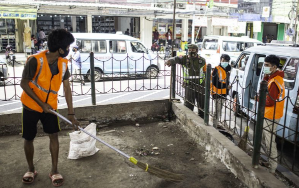 Warga yang melanggar aturan protokol kesehatan Covid-19 dikenakan sanksi menyapu sampah saat terjaring Operasi Tertib Masker.