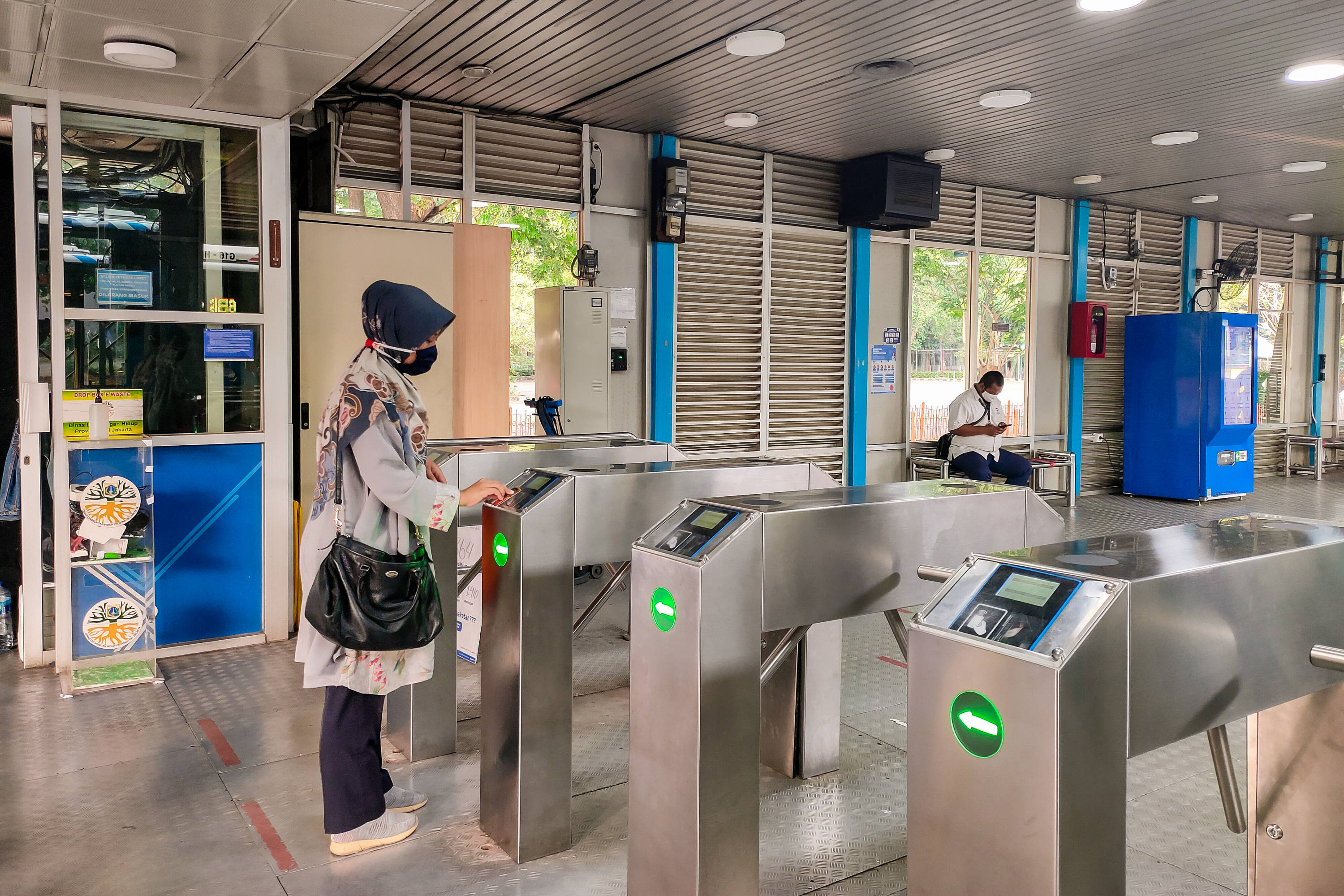 Ilustrasi: Seorang pekerja yang hendak berangkat dengan moda transportasi TransJakarta