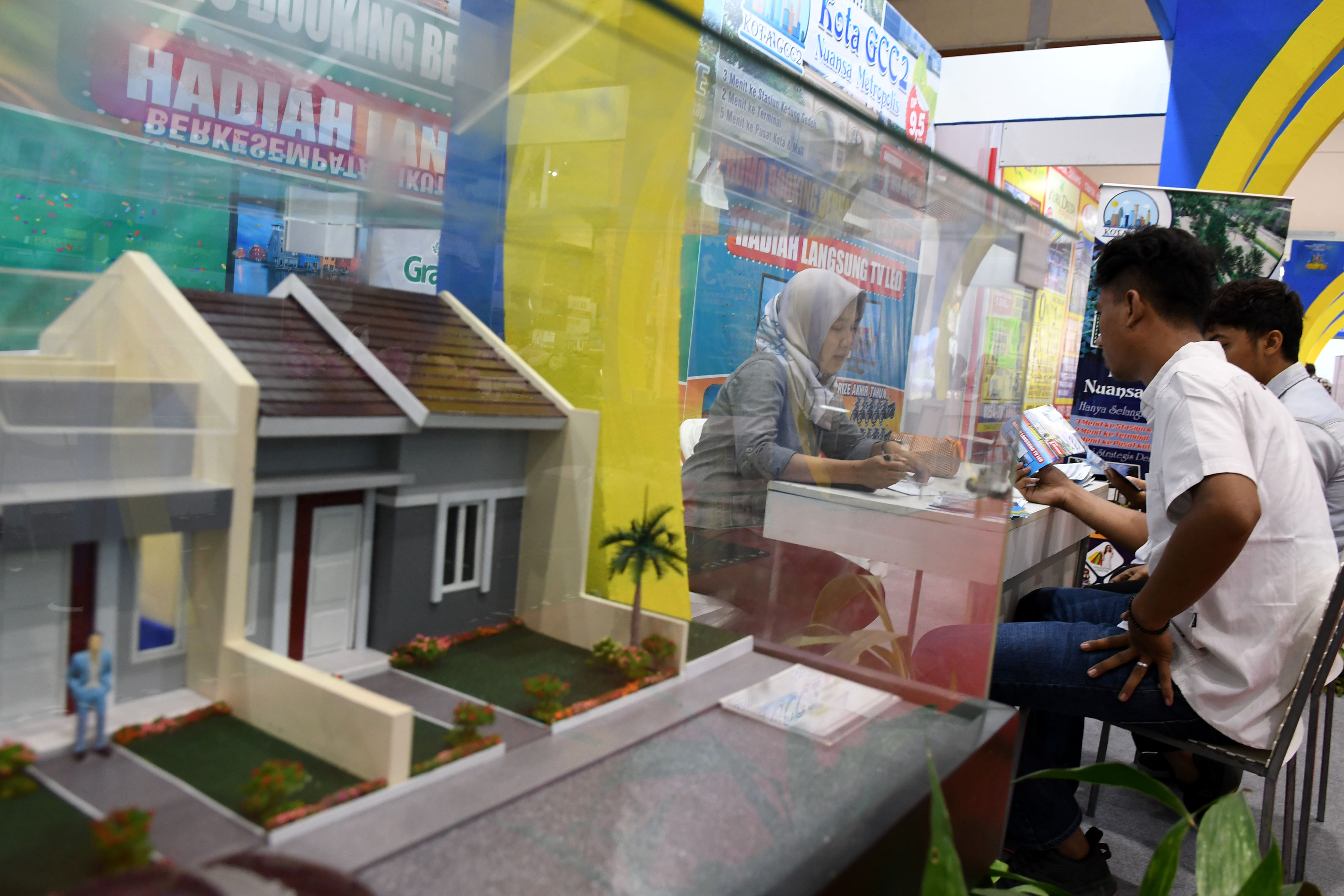 Petugas menjelaskan calon pembeli tentang salah satu perumahan yang ditawarkan dalam salah satu pameran properti di Jakarta.